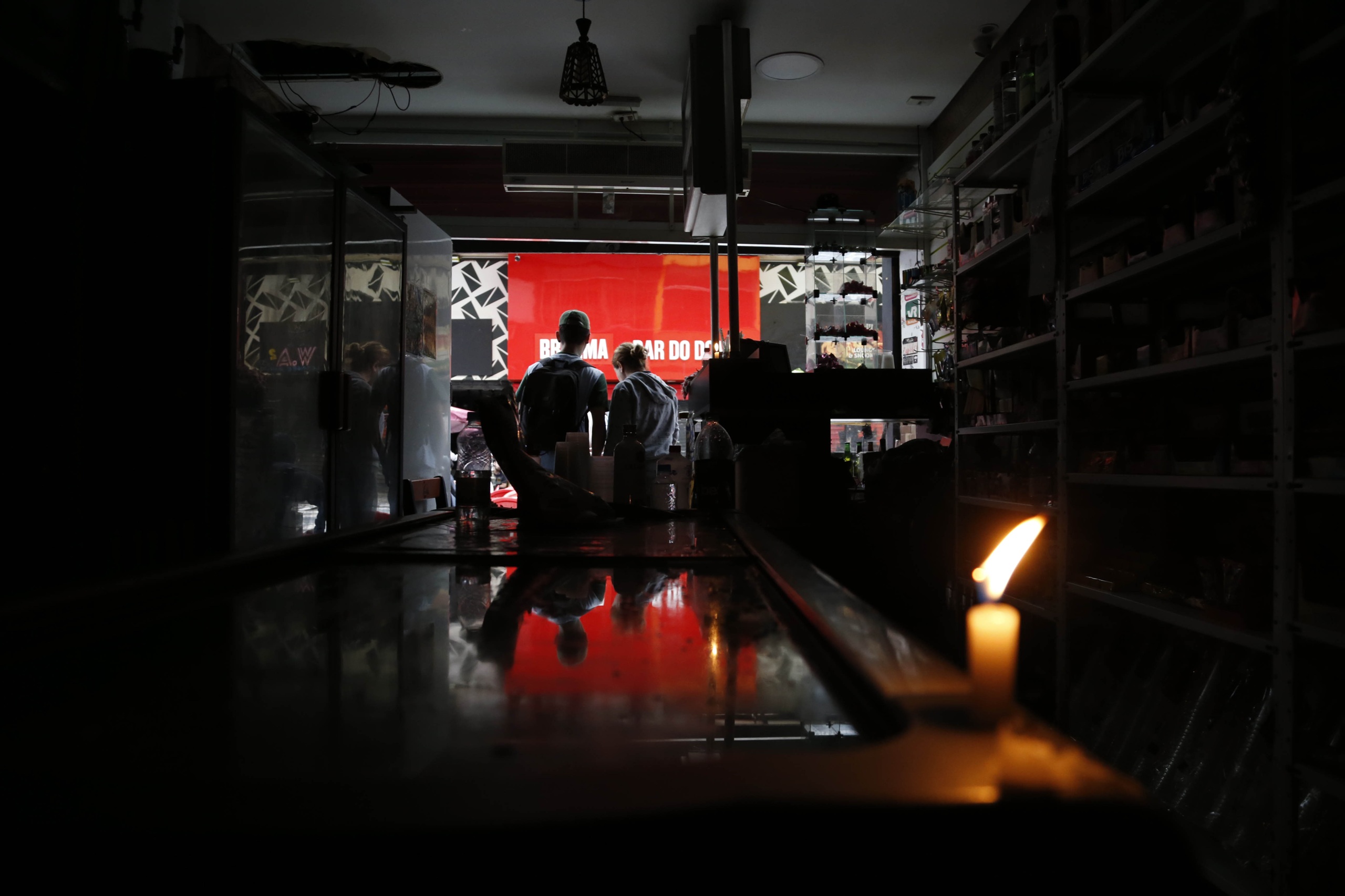 <p>Una vela ilumina una tienda en el centro de São Paulo, Brasil, durante los apagones de diciembre de 2024. Cada año,  ciudades latinoamericanas se enfrentan a cortes de electricidad provocados o intensificados por factores climáticos (Imagen: Paulo Pinto / Agência Brasil)</p>
