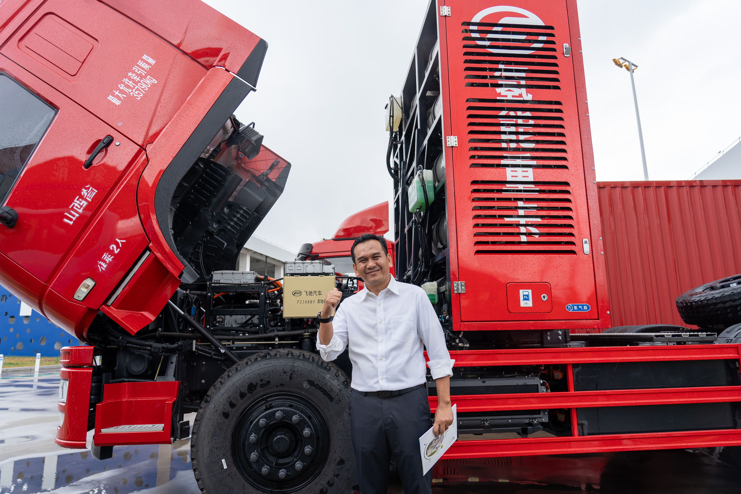 A man stands beside a red truck