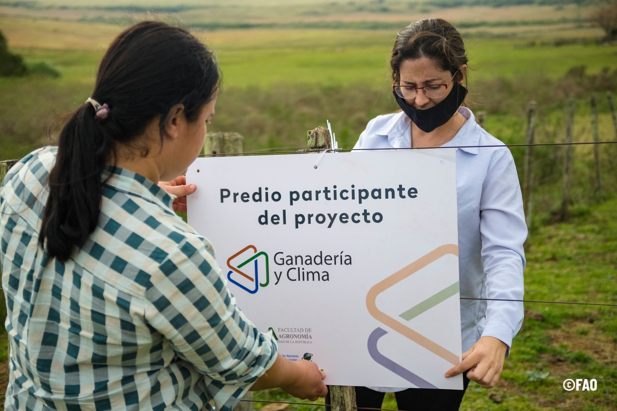 Mulher entrega cheque grande de projeto agrícola para produtora rural