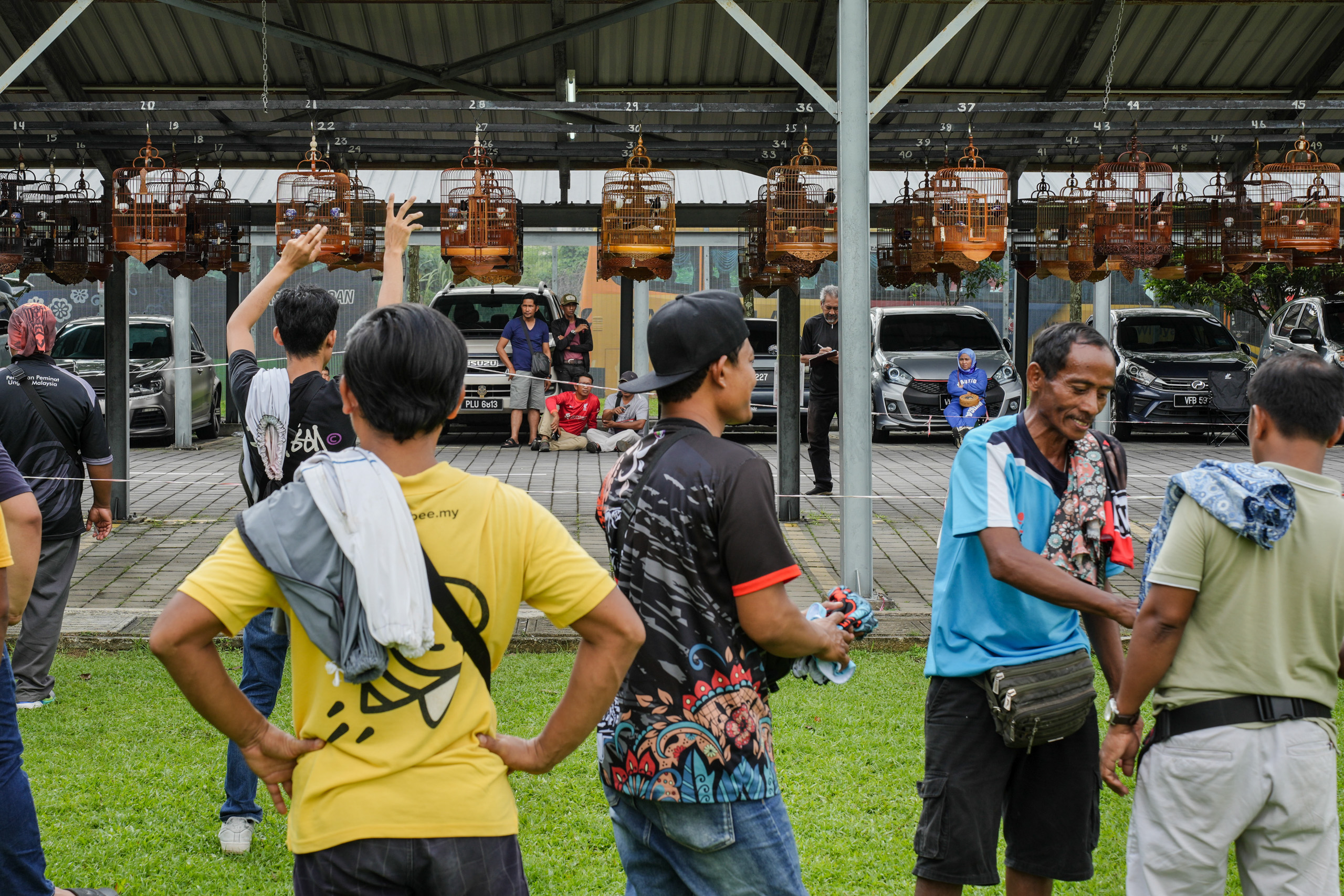 Bird owners whistle to their birds during a competition 