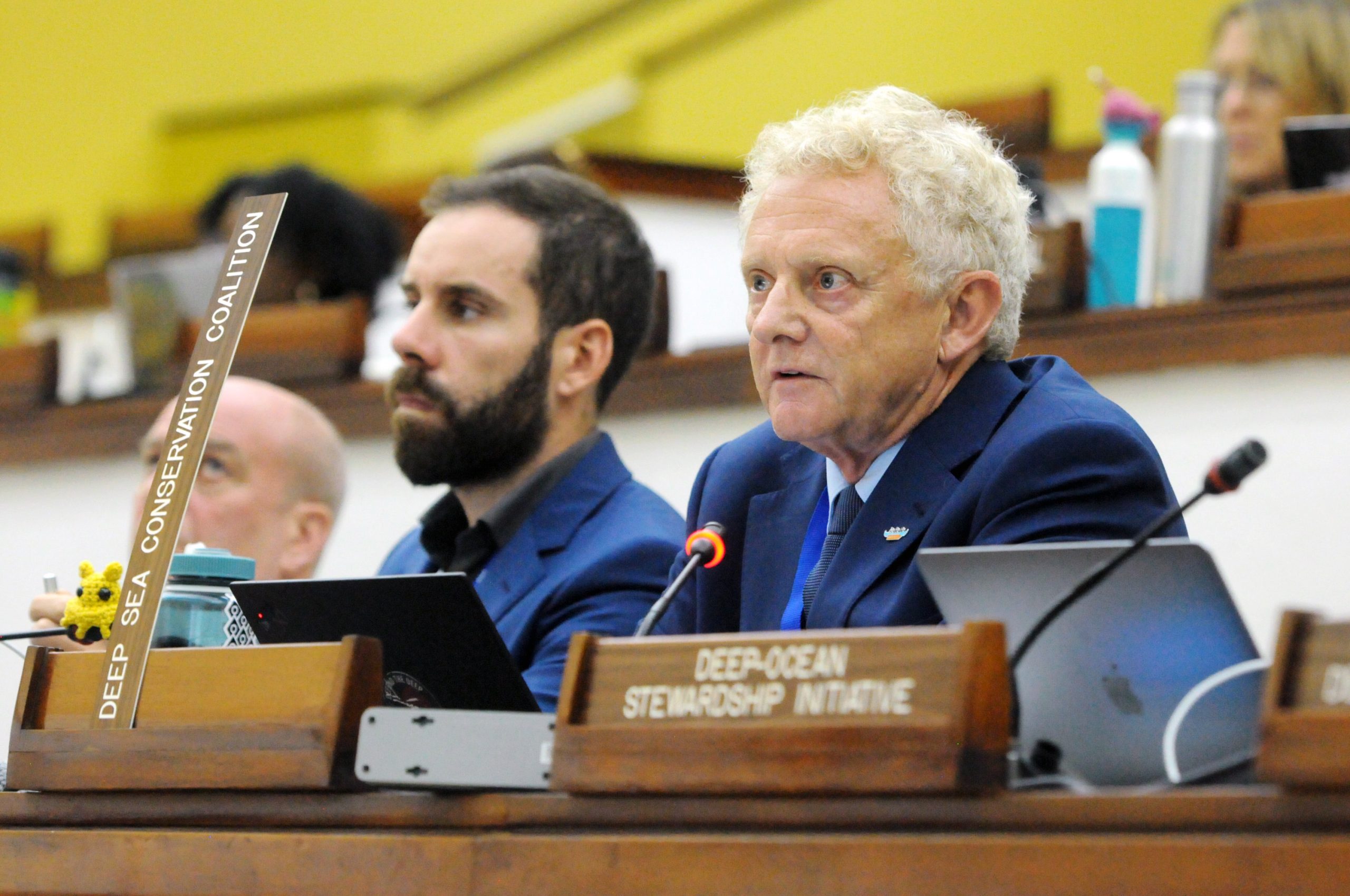 men sitting behind desks with microphones
