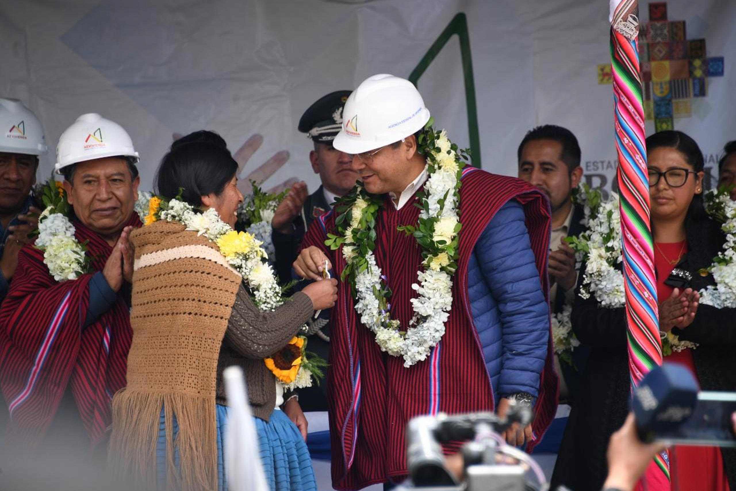 President Luis Arce among crowd wearing flower garlands