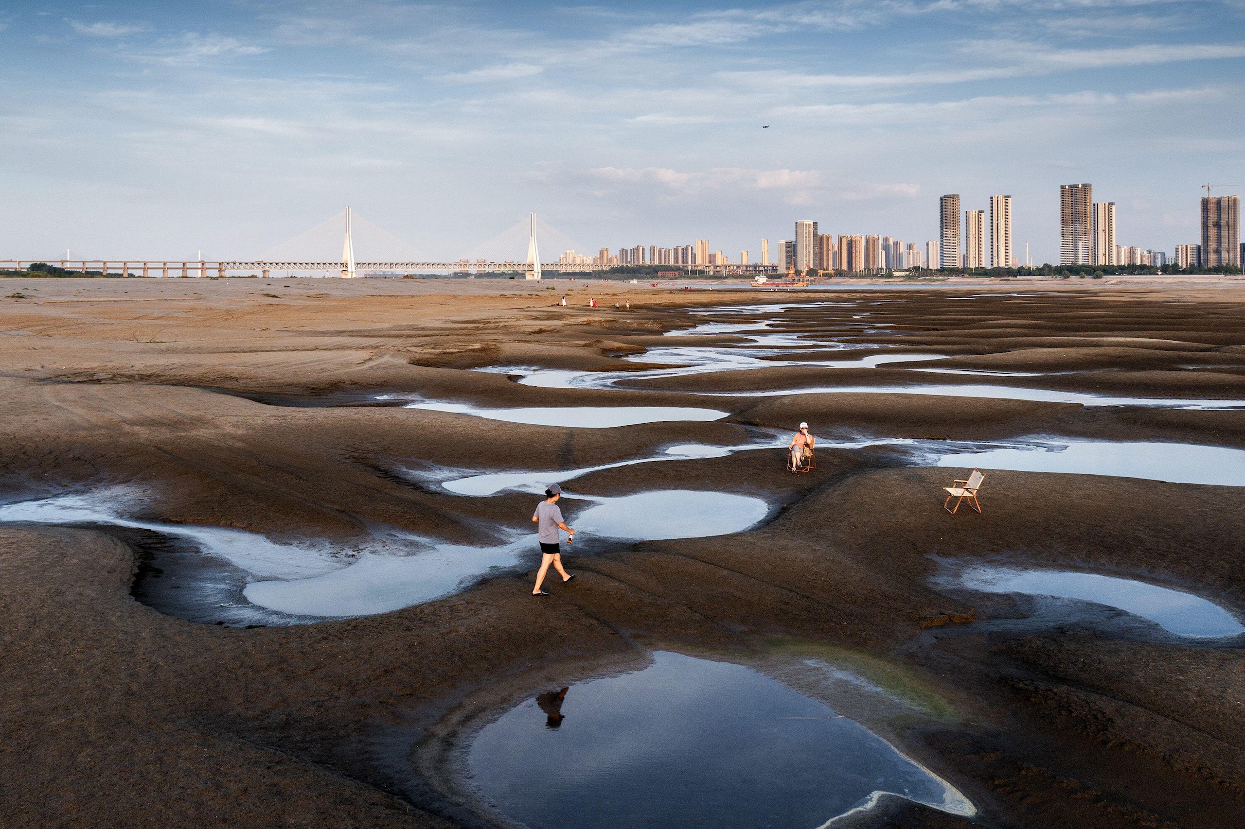 People walk on the exposed banks