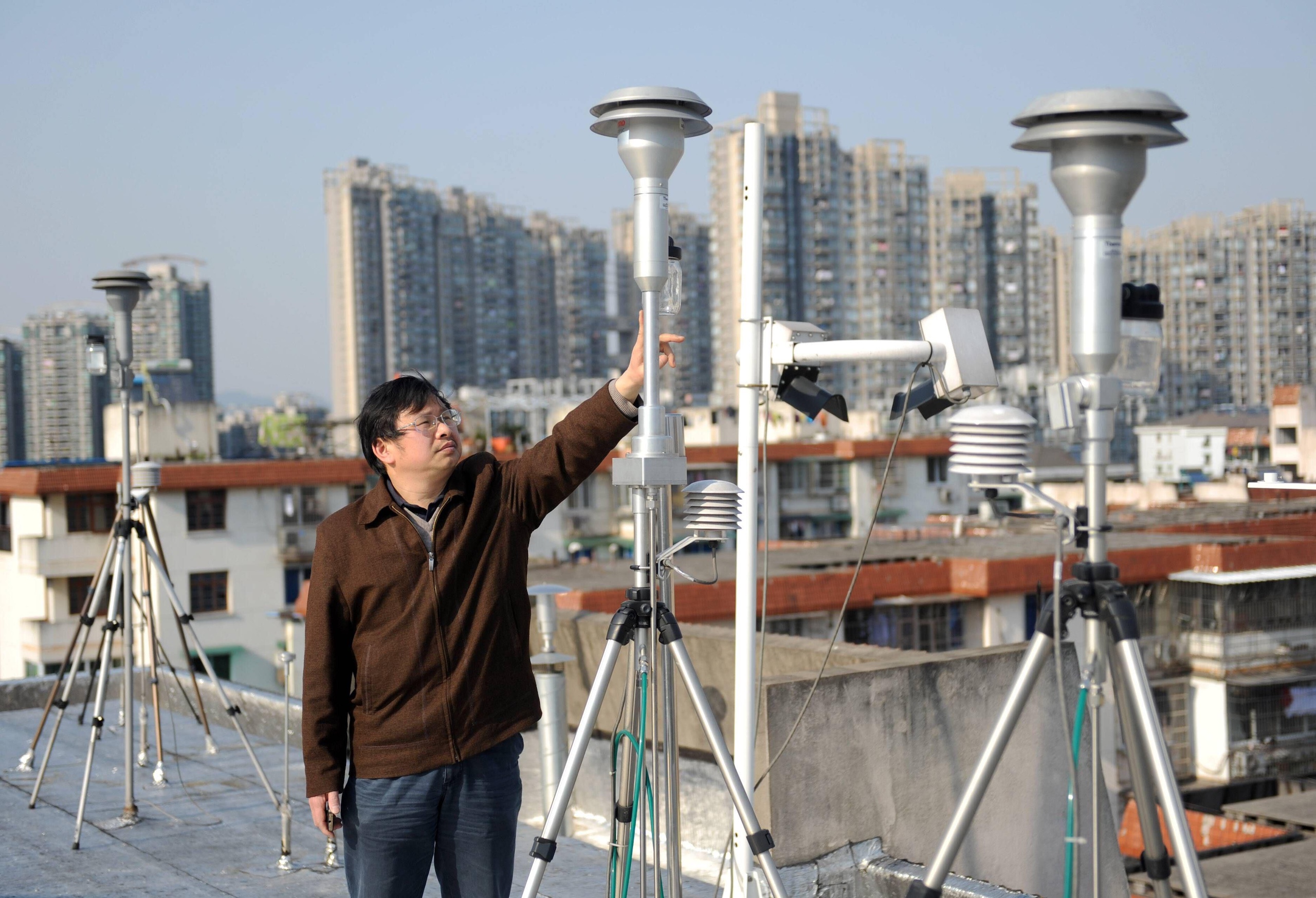 A staff check the PM2.5 monitors on a rooftop