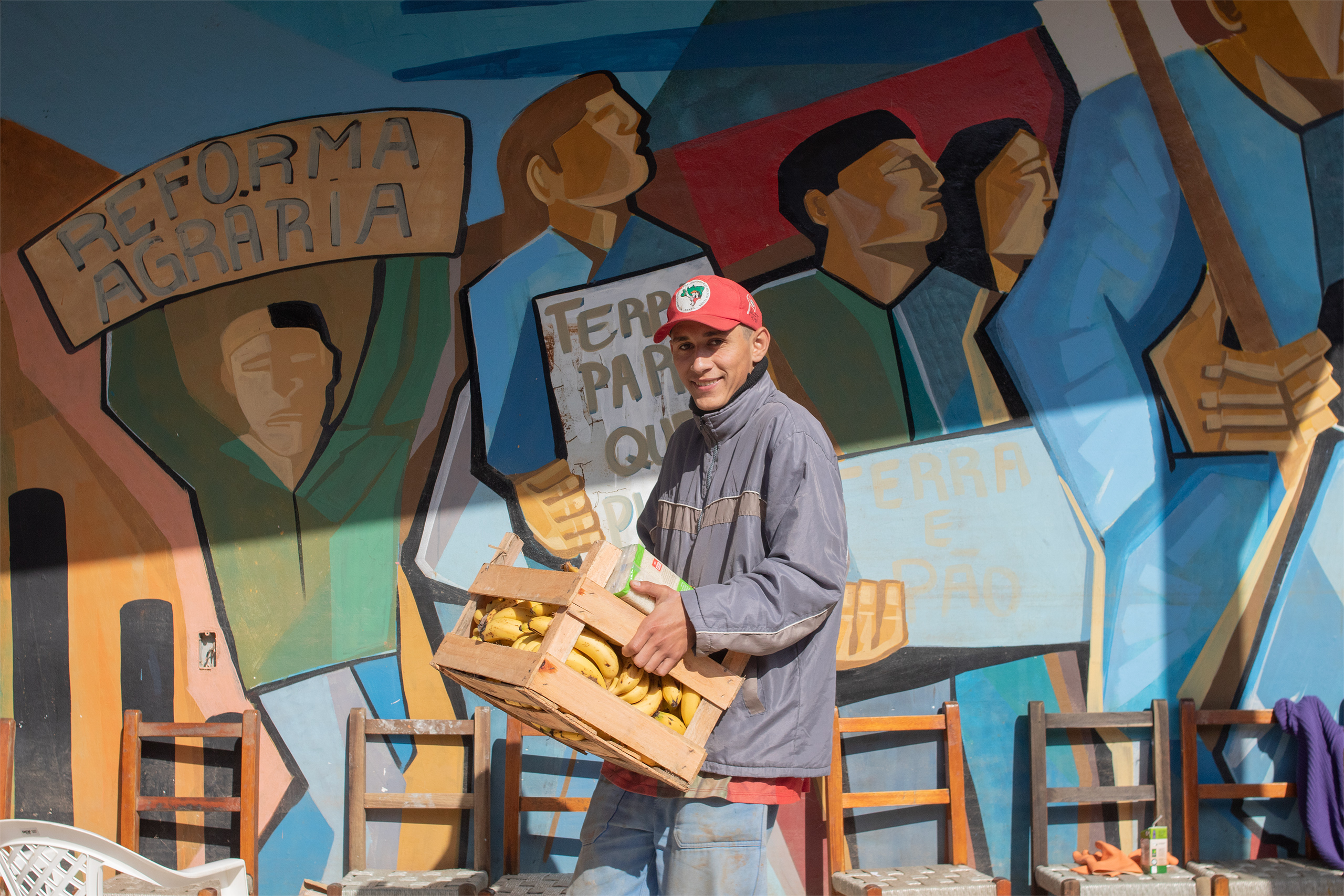 man carrying box of bananas
