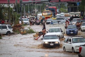Cars cross a flooded street