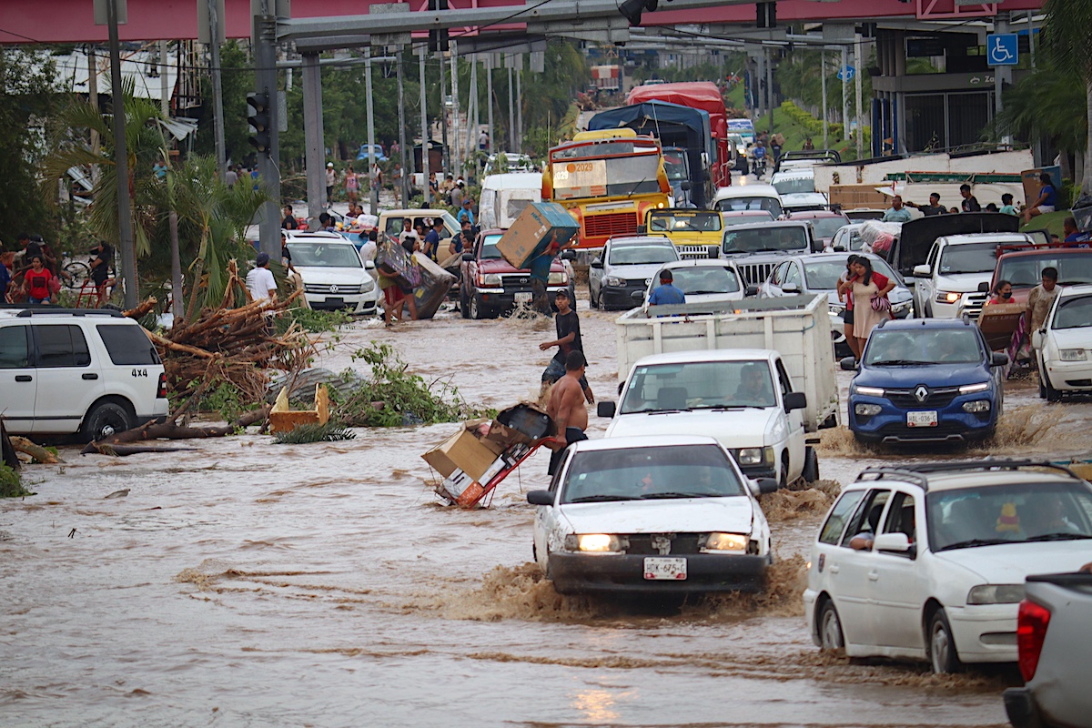 Cars cross a flooded street