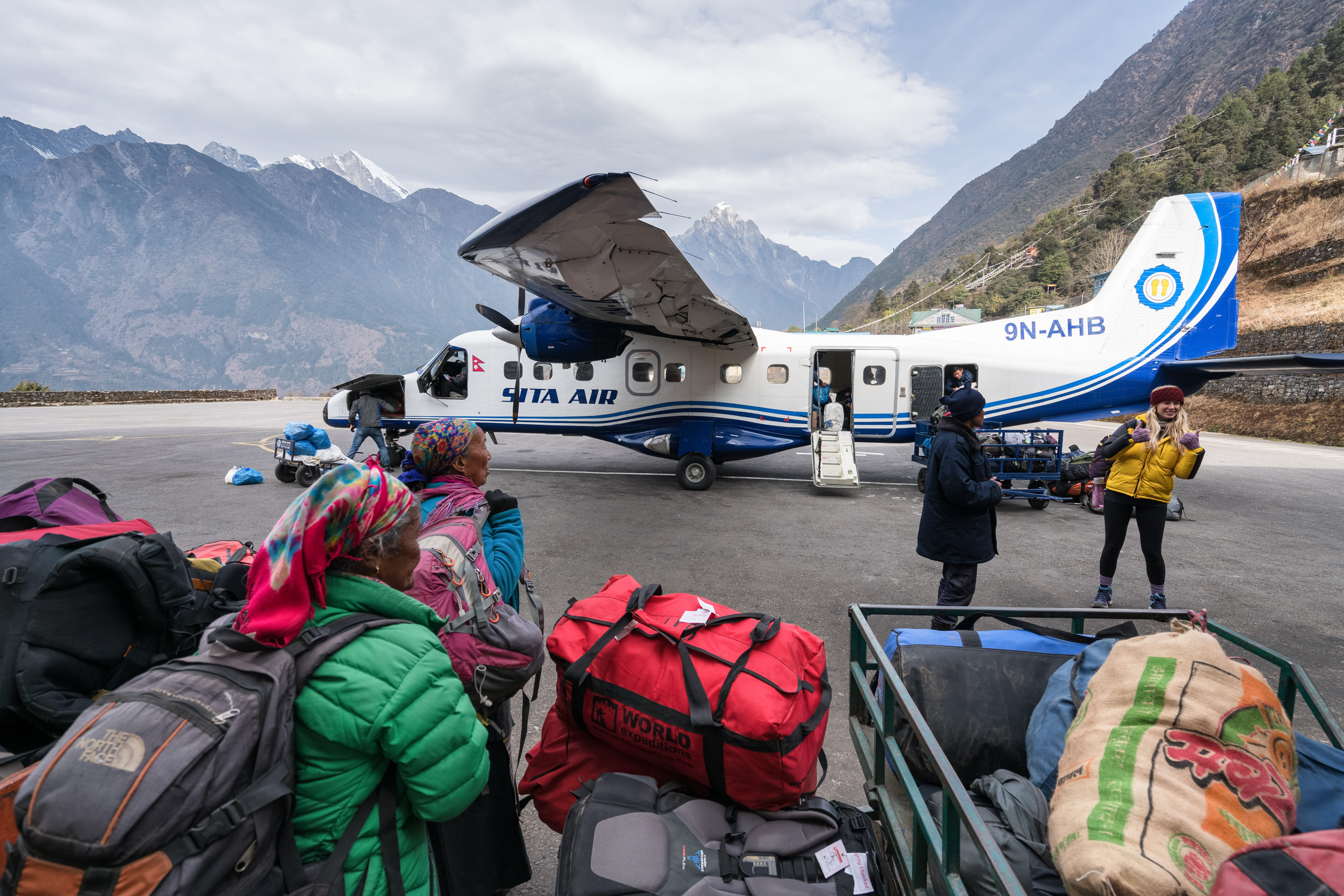 people and luggage near small plane