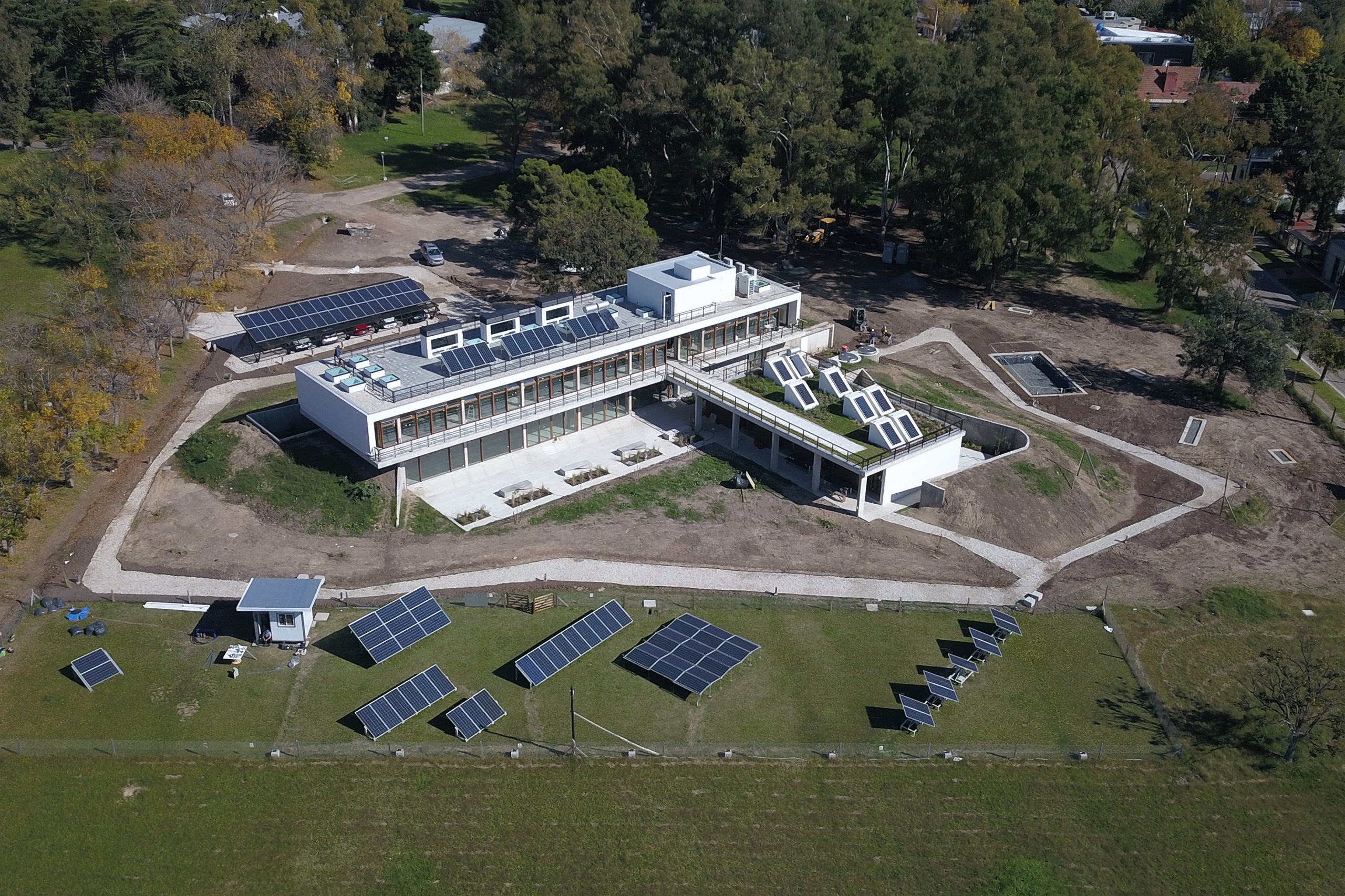 Prédio em campo aberto com painéis solares no teto e no jardim