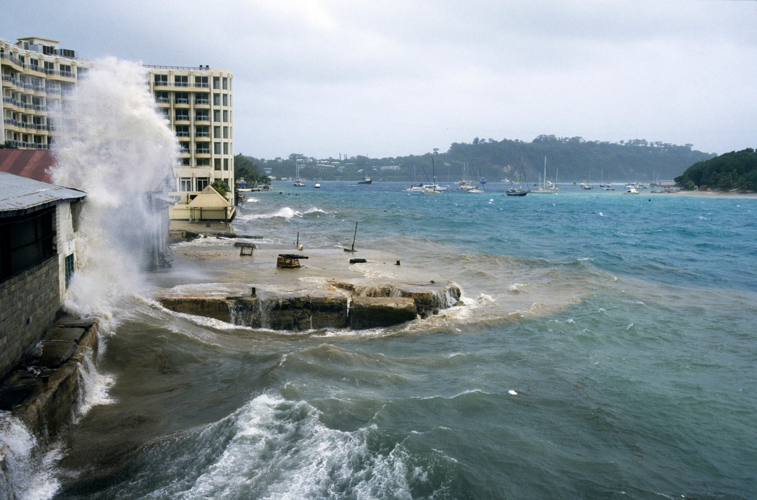 large wave crashing into building