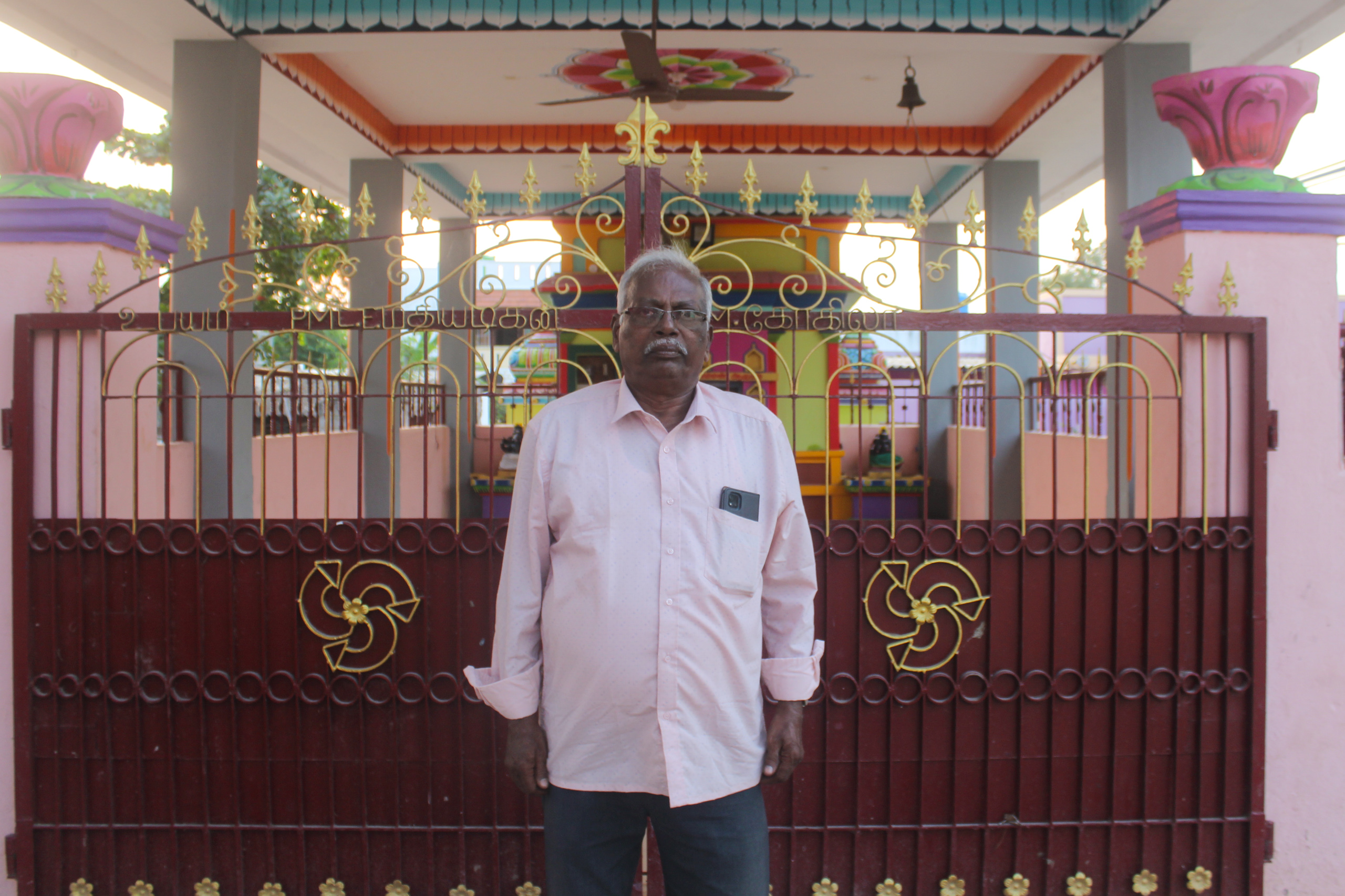 A man stands in front of a temple