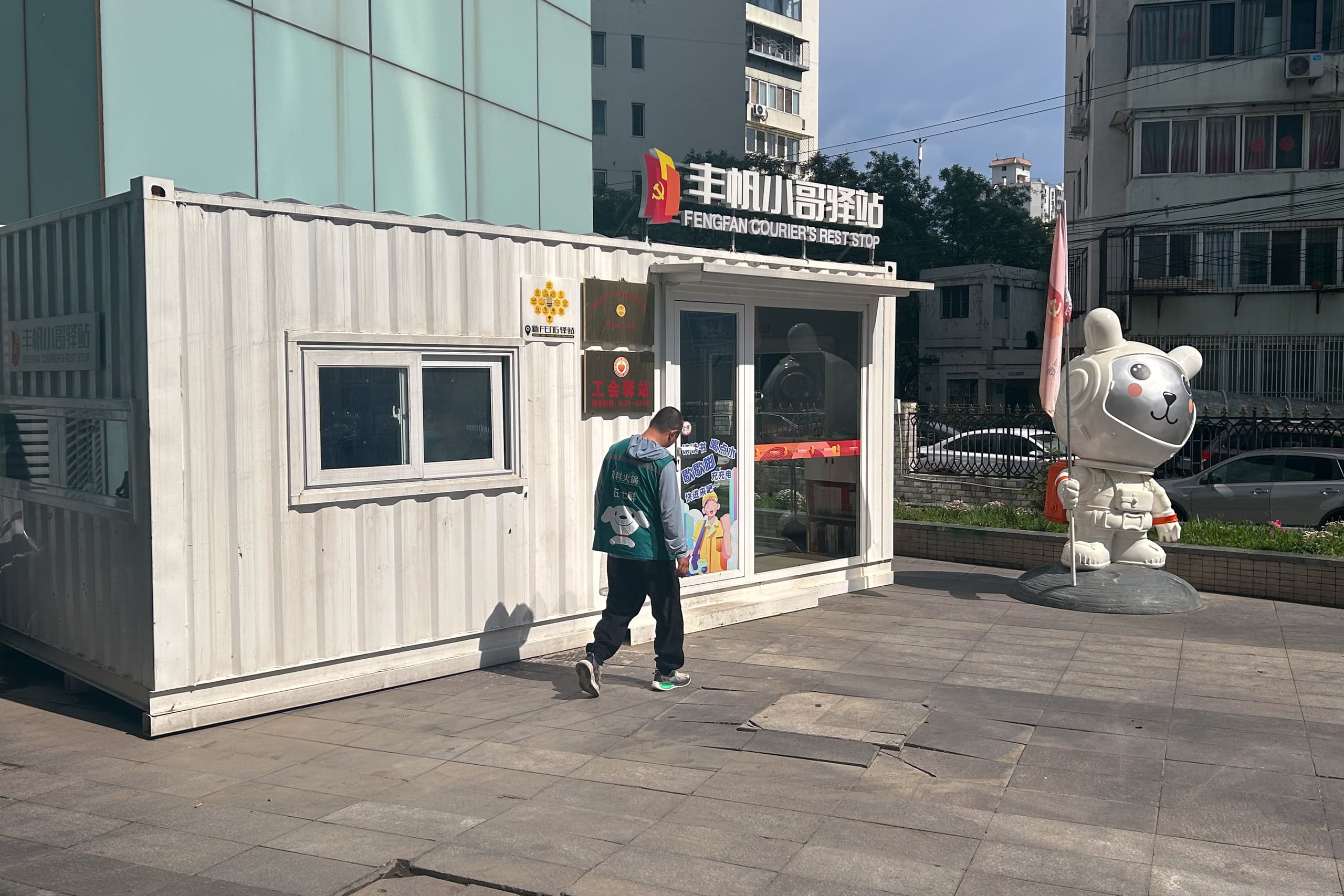A outdoor worker goes into a white container to escape the heat and have a rest