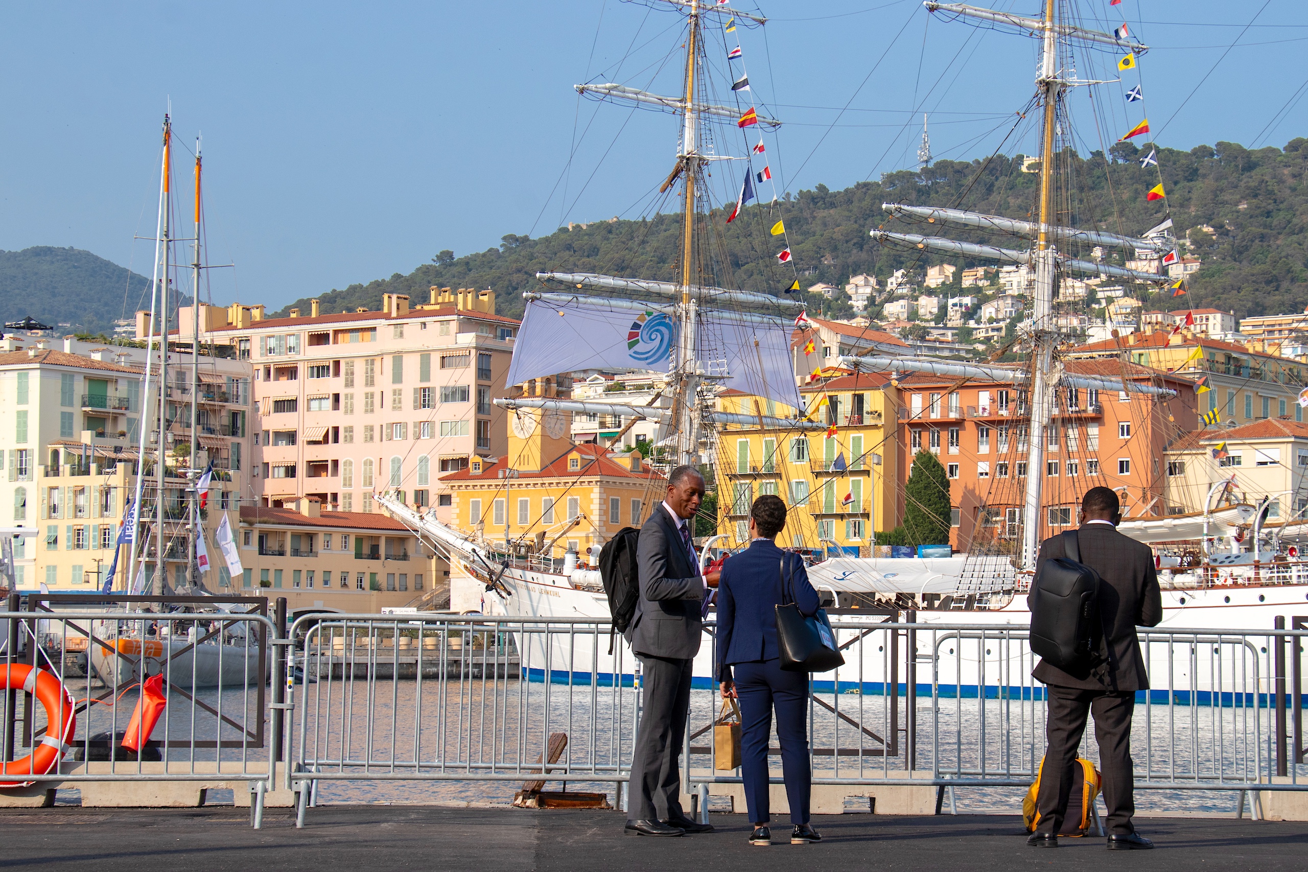 Several individuals gather near a large ship