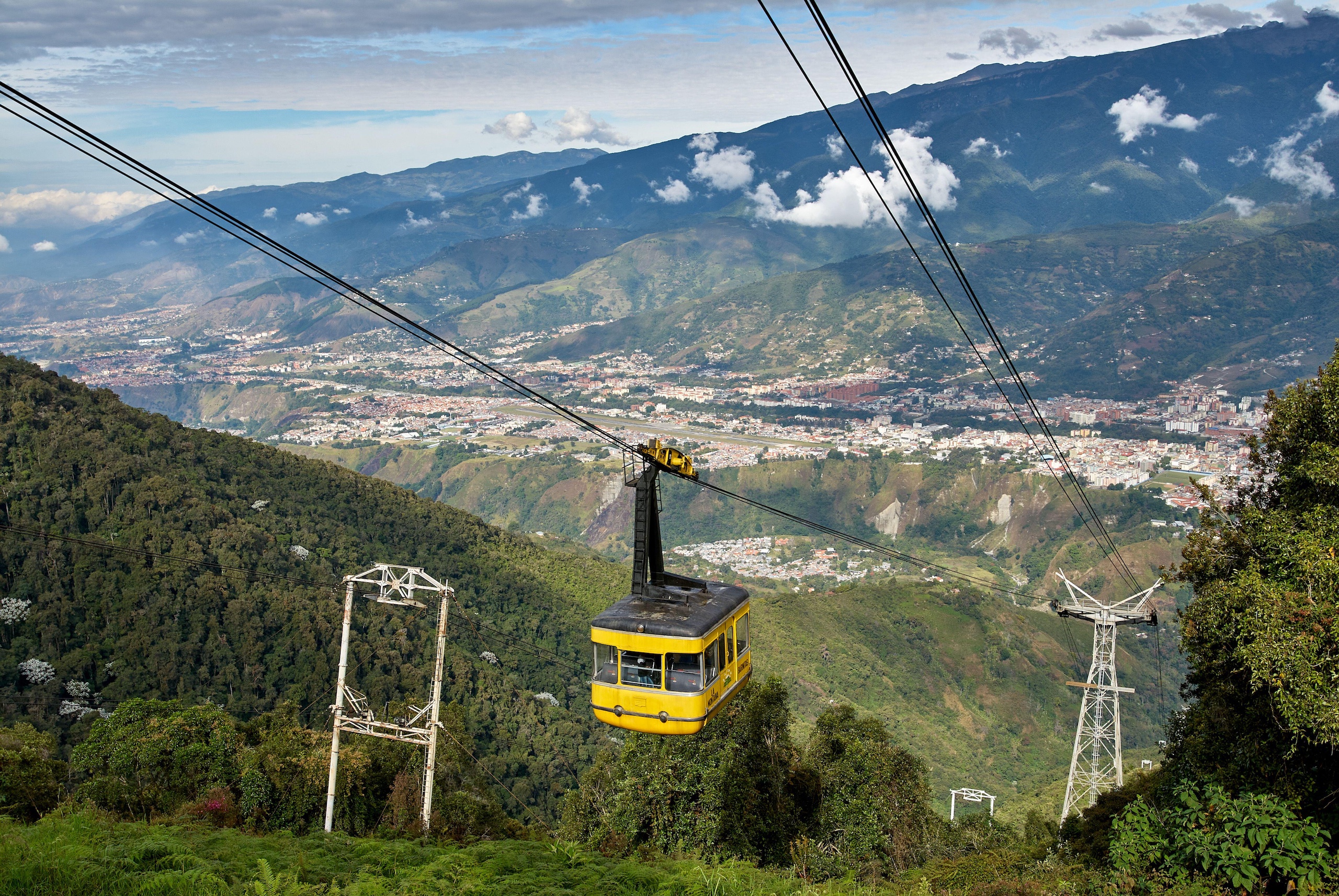 A cable car travels upward along a mountain slope
