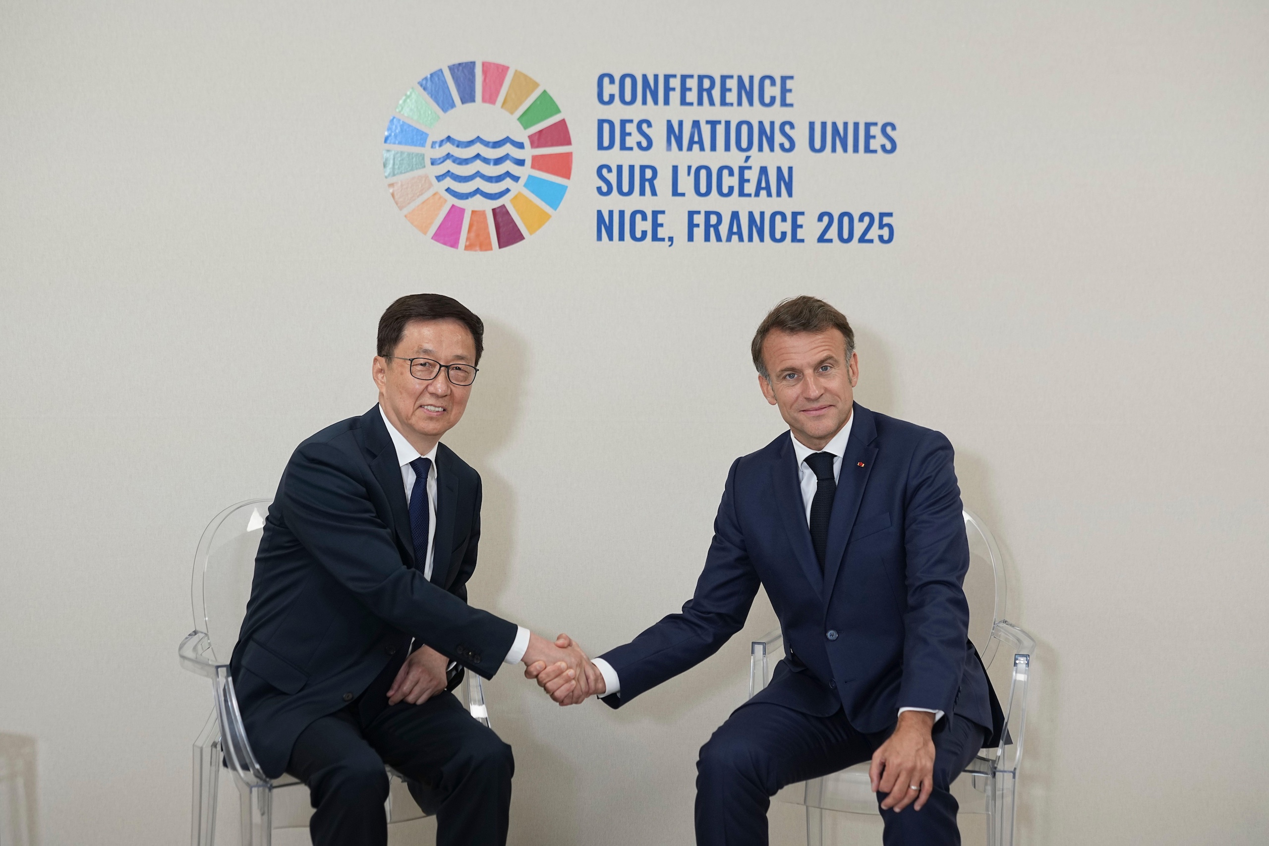 China's Vice President Han Zheng shakes hands with France's President Emmanuel Macron in Nice UN ocean conference