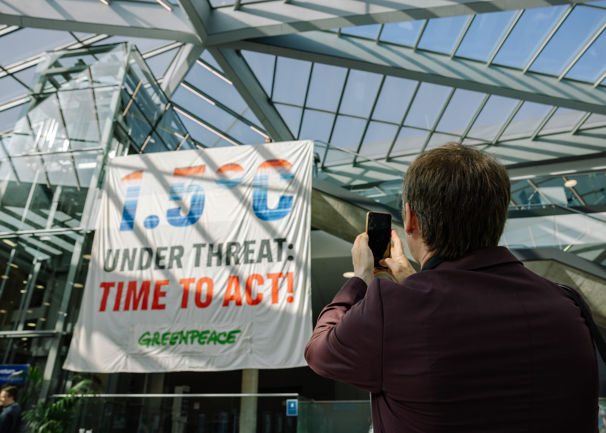 a man uses his phone to take photo of a banner