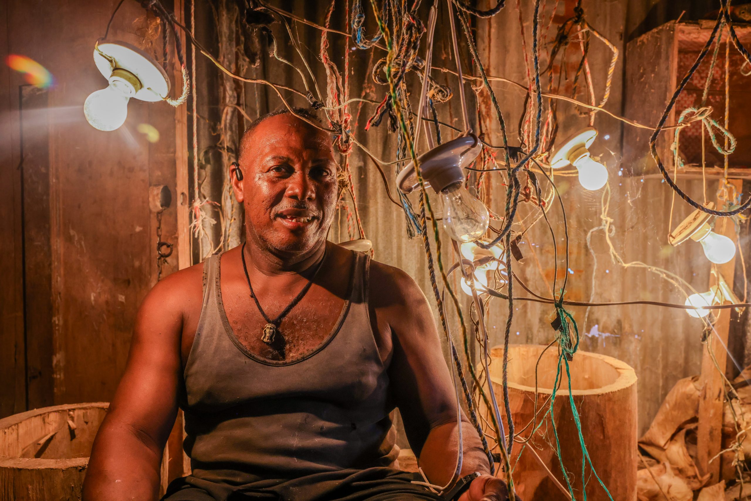 man surrounded by lightbulbs and string