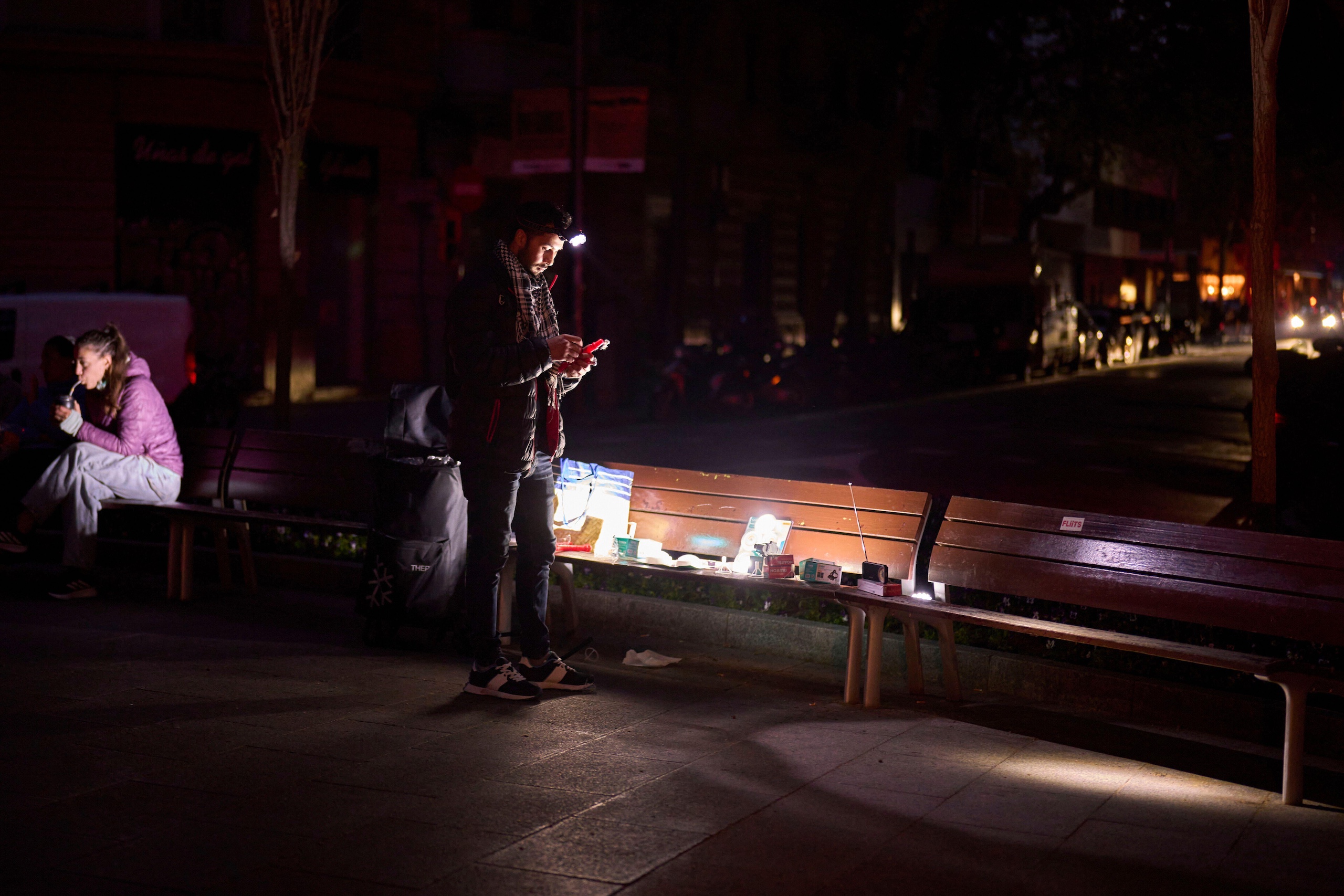 A man sells battery-powered radios and torches on a street during the blackout in Barcelona