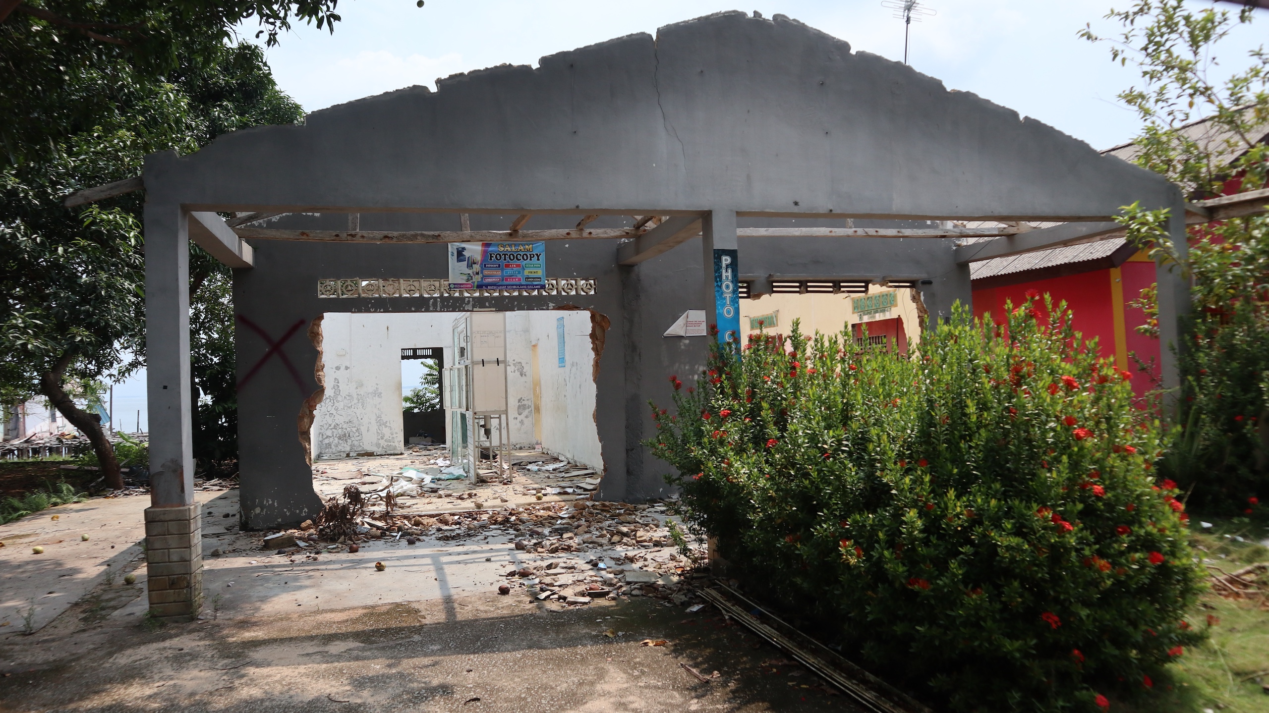 <p>A partially demolished house in one of the <em>Kampung Tua </em>(old villages) of Rempang Island, previously owned by a household that agreed to relocate to make way for the Rempang Eco City megaproject (Image: Bagus Pradana / Transparansi Internasional Indonesia)</p>