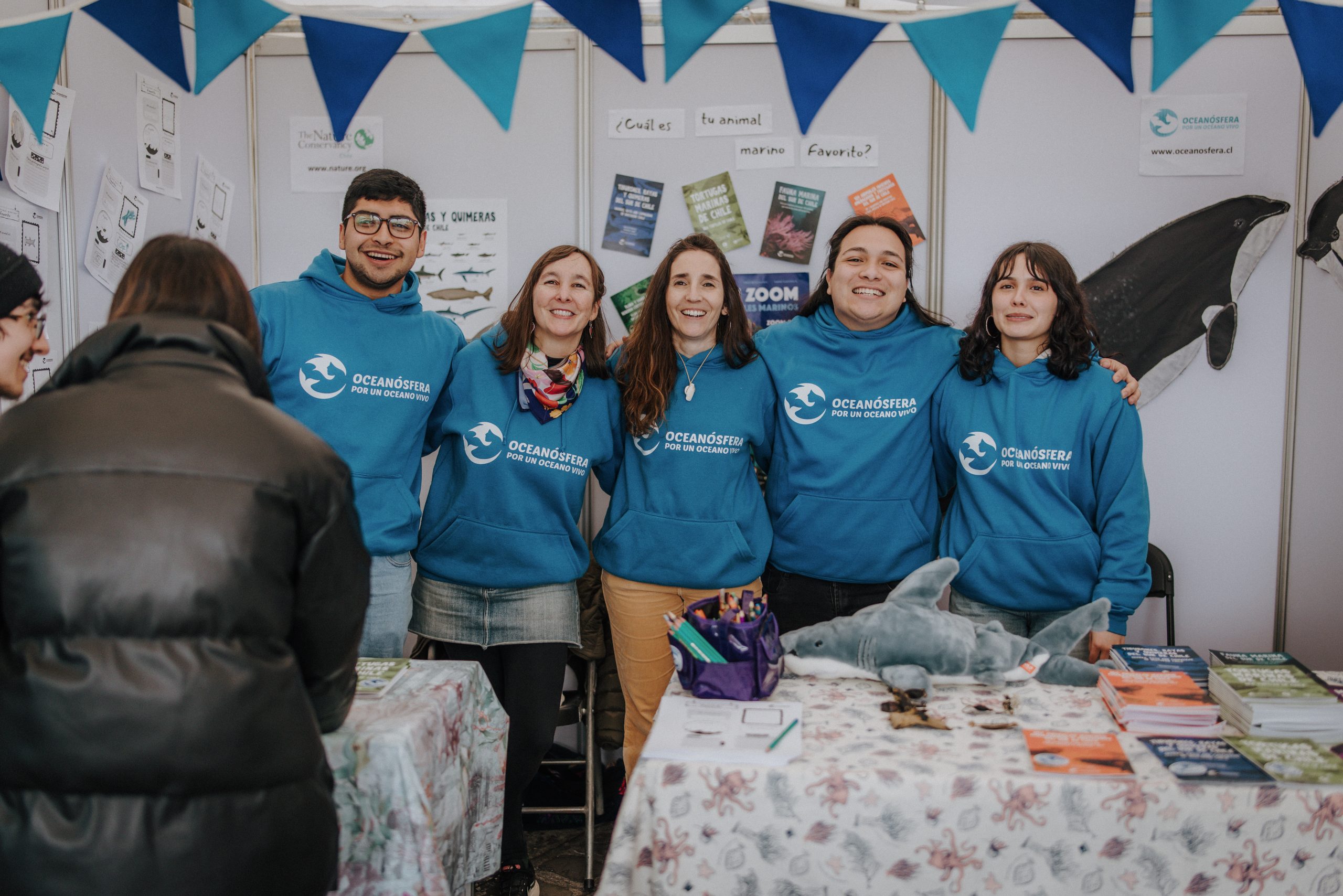 Un grupo de personas con sweaters azules que dicen "Oceanósfera" posando