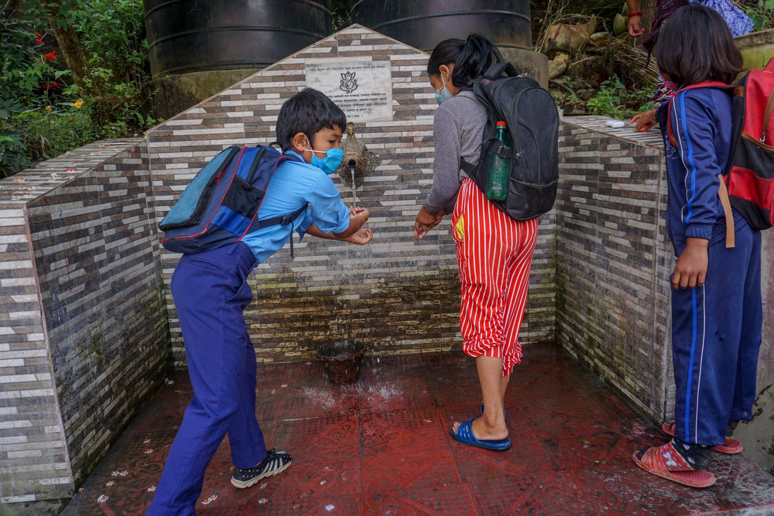 children wearing masks at standpipe