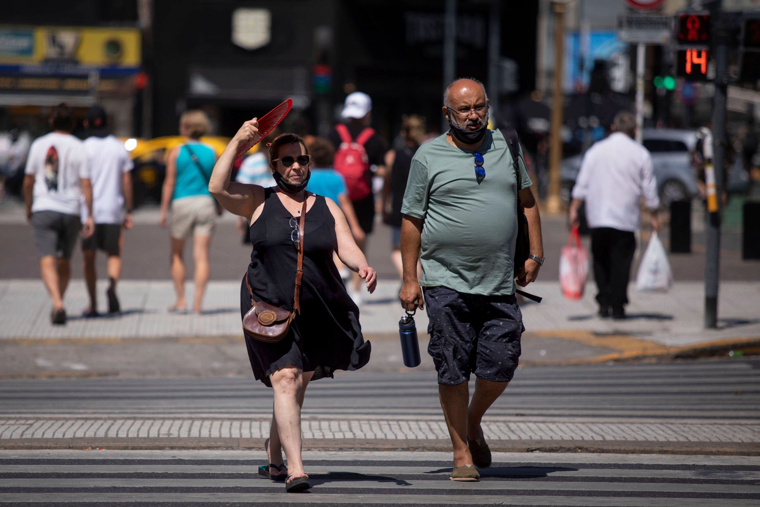 Un hombre y una mujer cruzando una calle por la senda peatonal