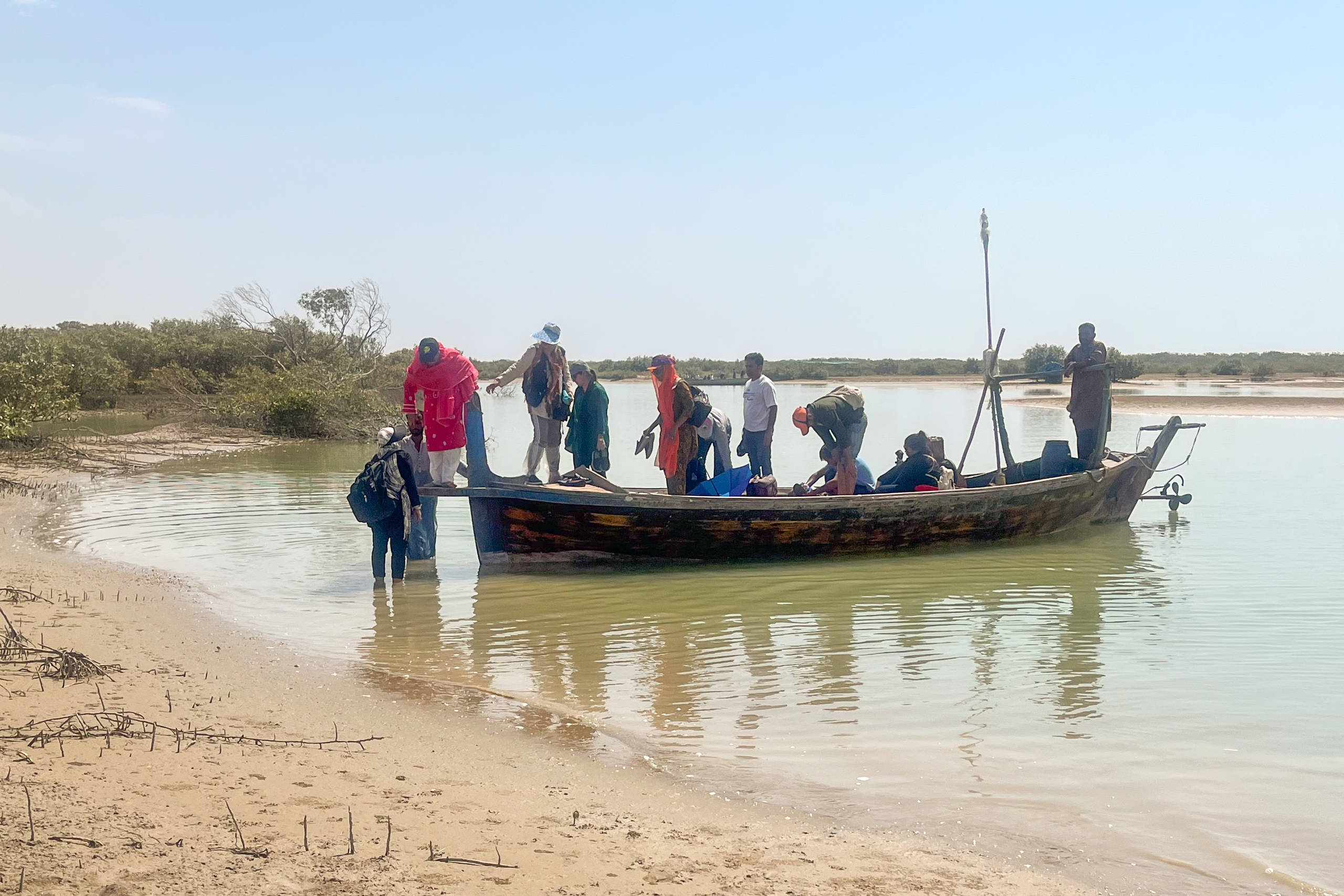 group of people getting off narrow boat near shore