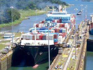 Container ship carrying cargo through canal
