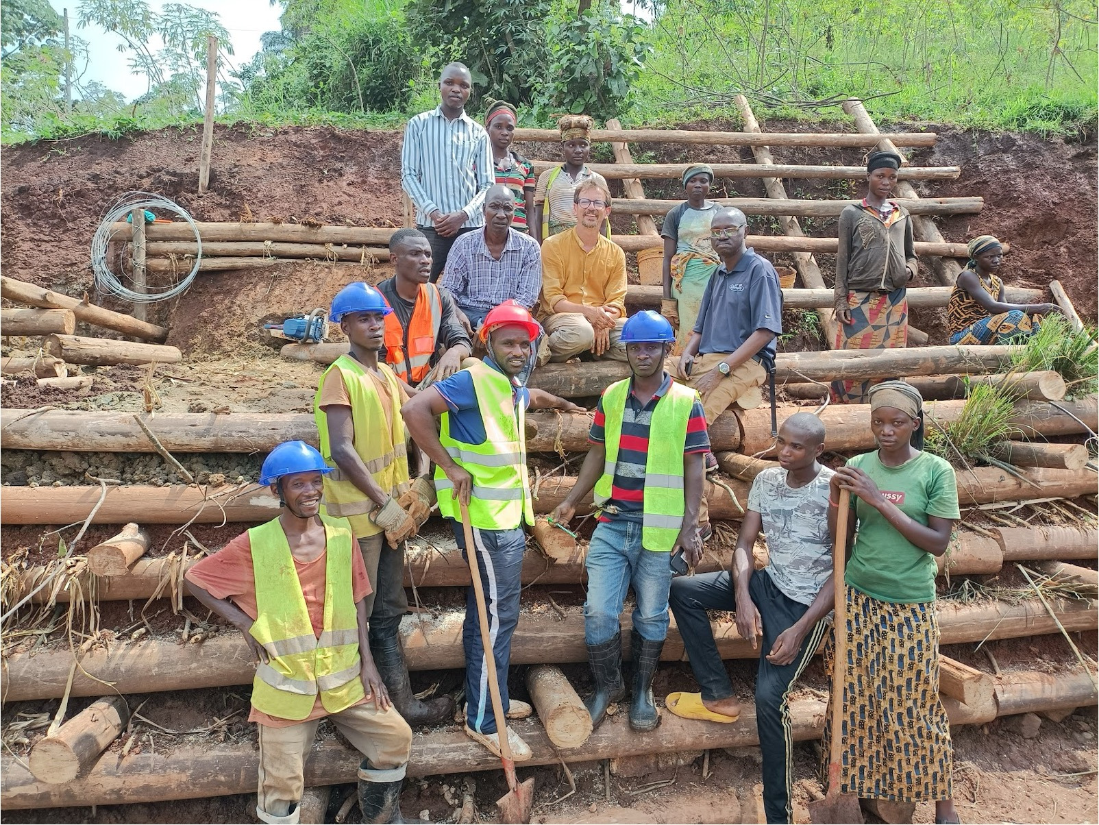 group of people wearing protective equipment standing near wood based retaining wall