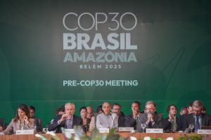 group of people wearing business attire seated beneath cop30 sign