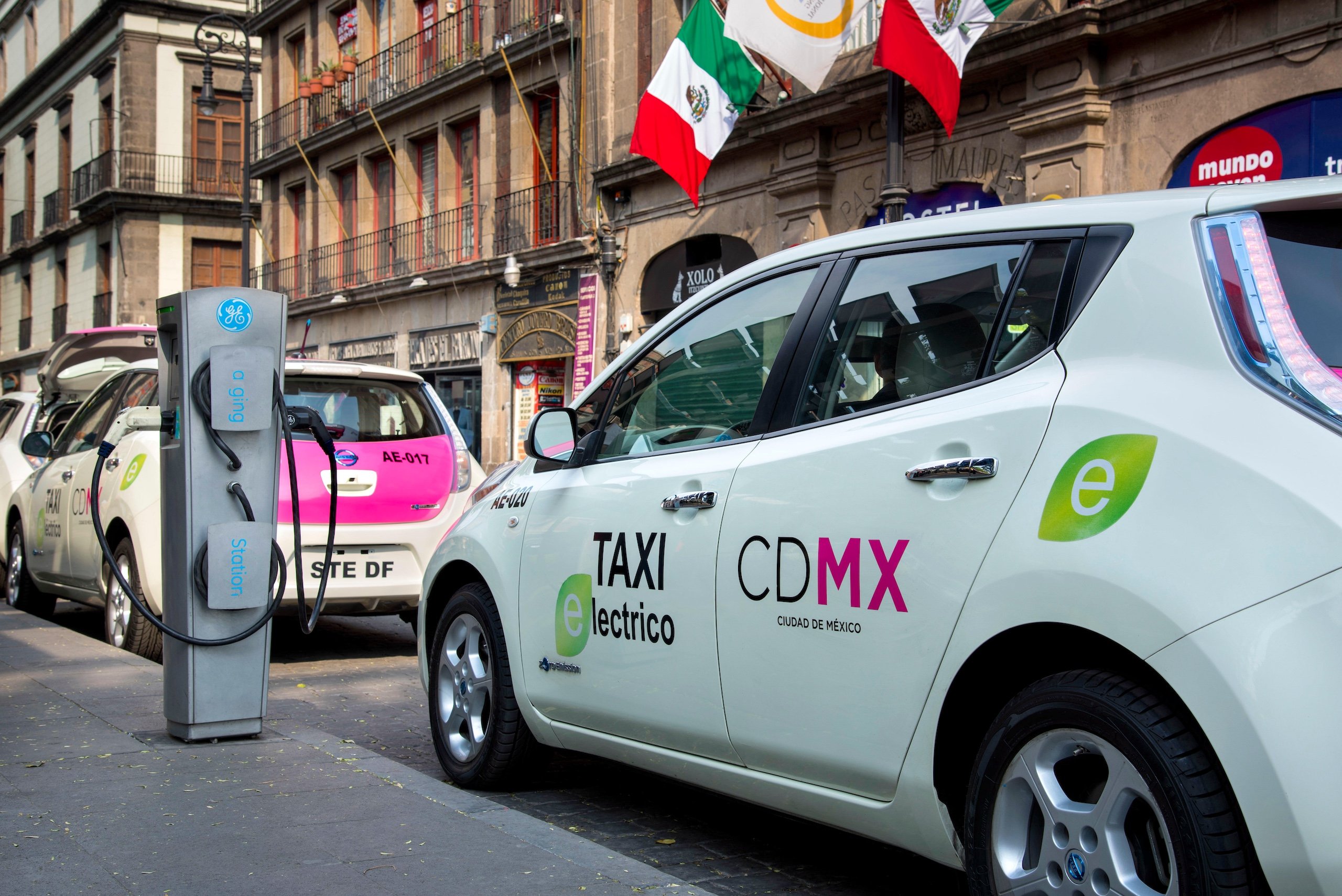 Táxis elétricos estacionados ao lado de uma estação de recarga na Cidade do México
