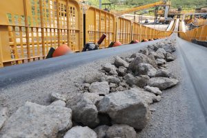 a conveyor belt carrying gravel and rocks at a construction site