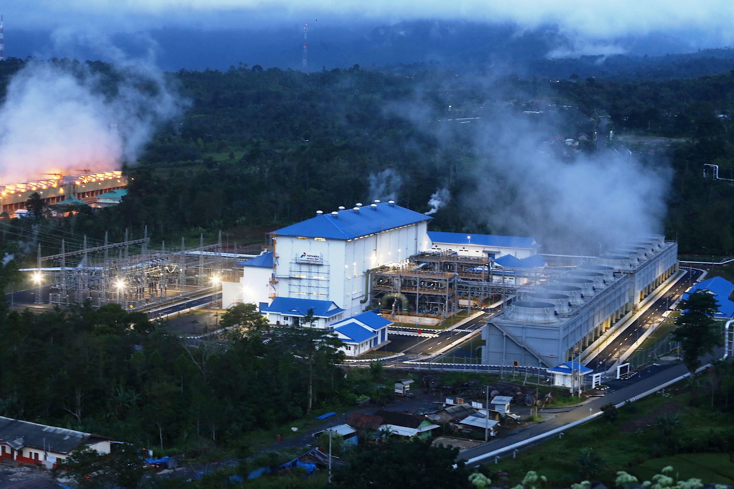 A geothermal power plant emits steam under the morning atmosphere