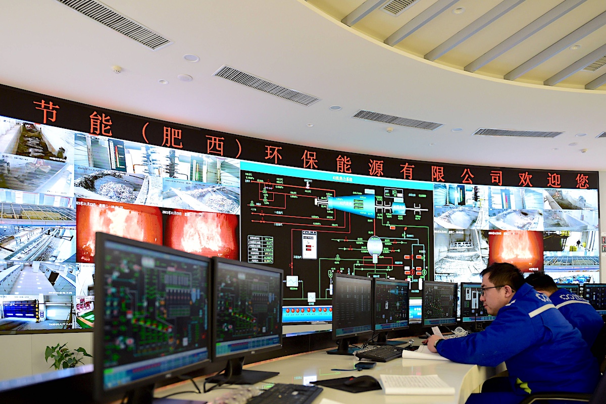 A control room with multiple screens displaying waste to electricity process