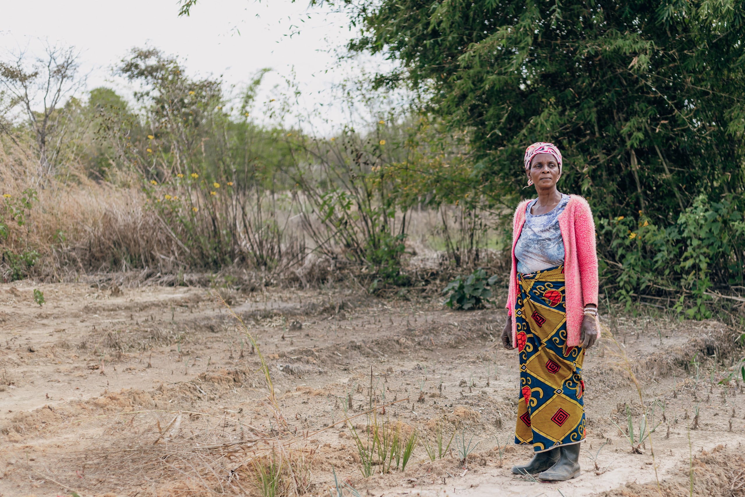 Una mujer está de pie en un campo seco 