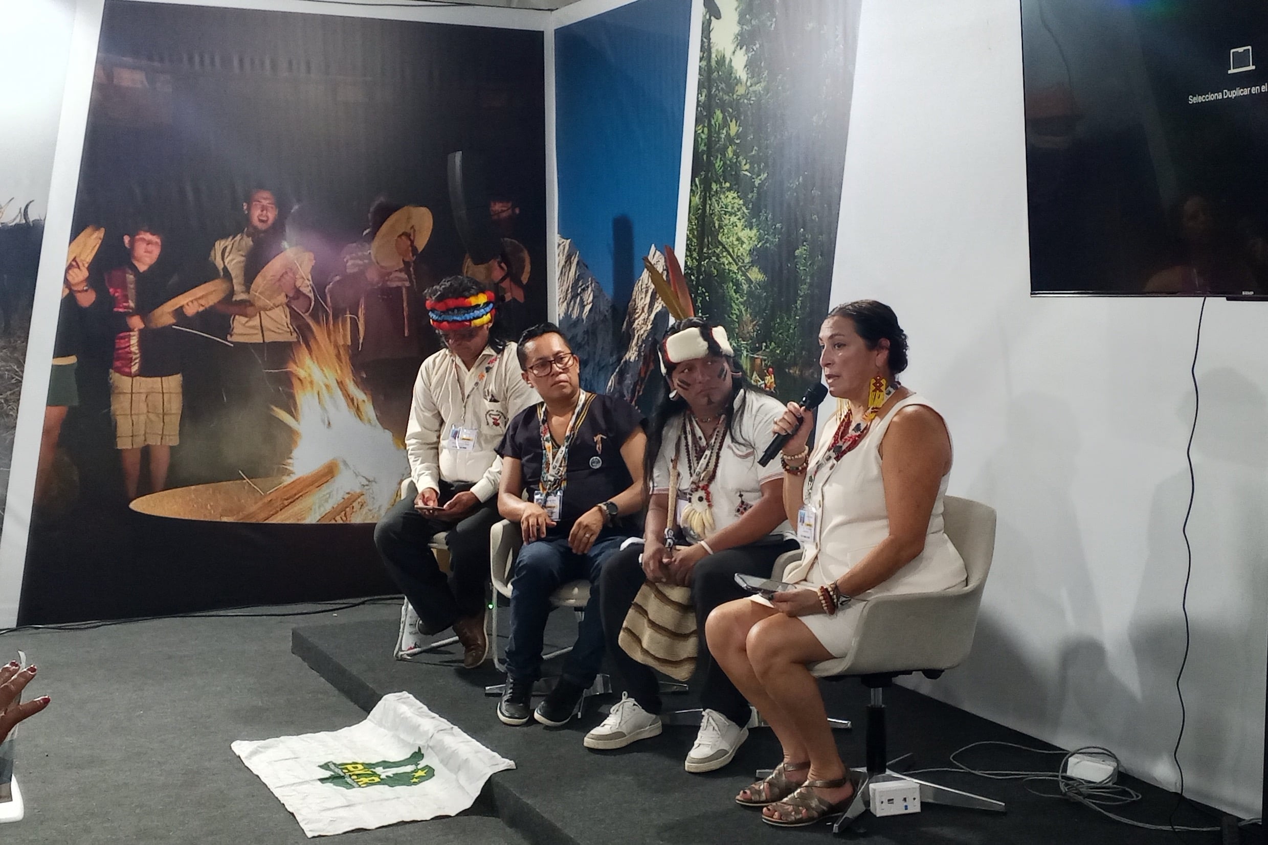 Juan Bay (ao centro, com bolsa e coroa de penas) participa de painel da COP30