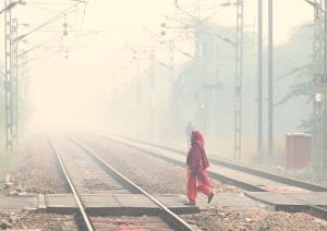 woman crossing railway tracks in smog