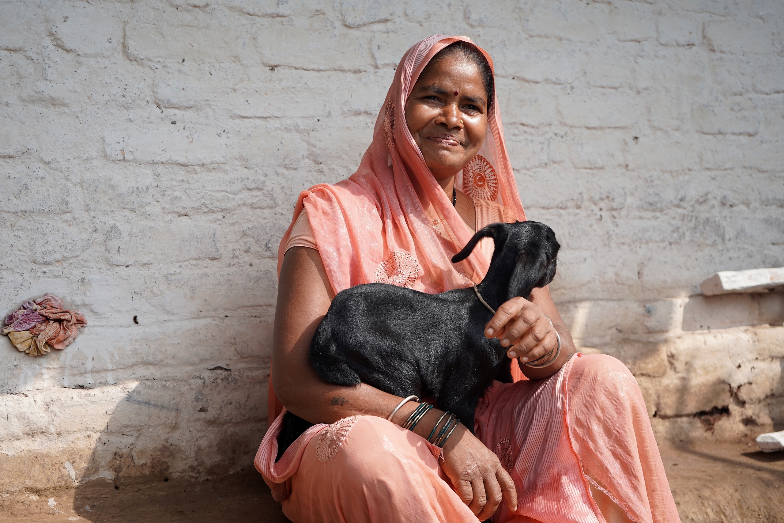 seated woman holding goat