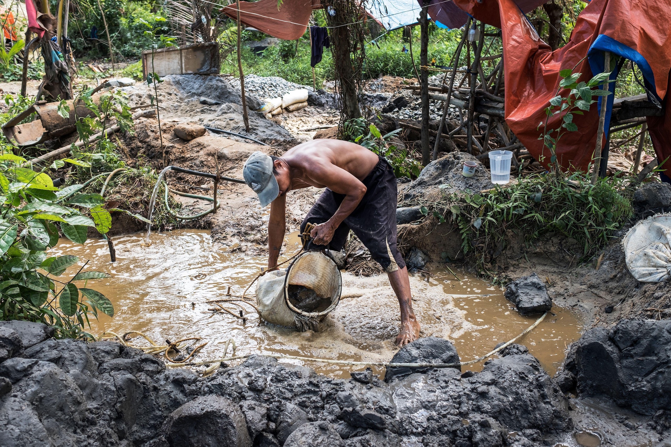 <p>A miner sifts for gold in Paracale, a municipality of the Philippines (Image: Erberto Zani / Alamy)</p>