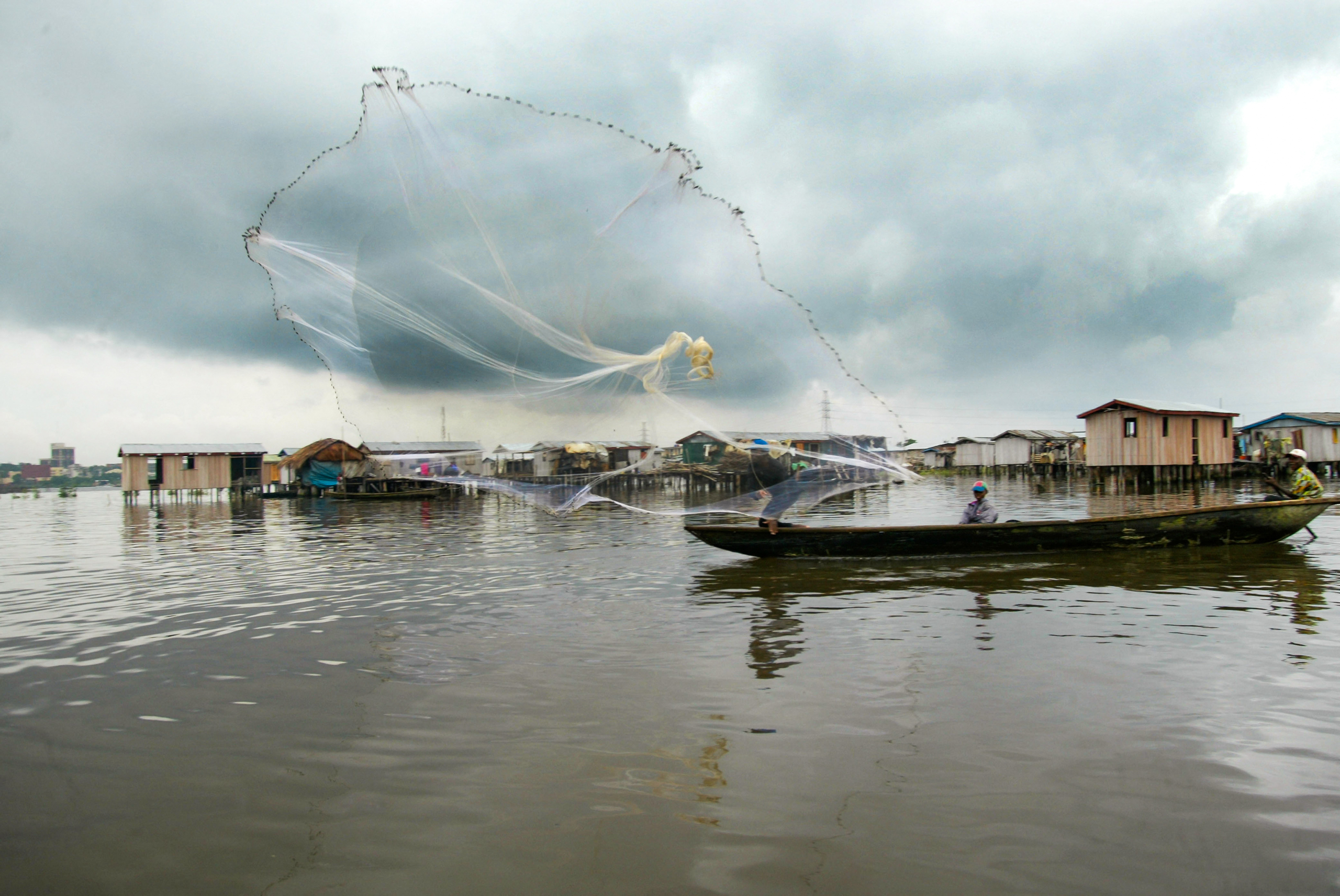 <p>A fisher casts his net in the waters of Lagos, Nigeria. “Ghost gear” – abandoned, lost or discarded fishing nets – in the country’s waters harm marine life and potentially fishers’ livelihoods and the economy (Image: Ton Koene / Alamy)</p>