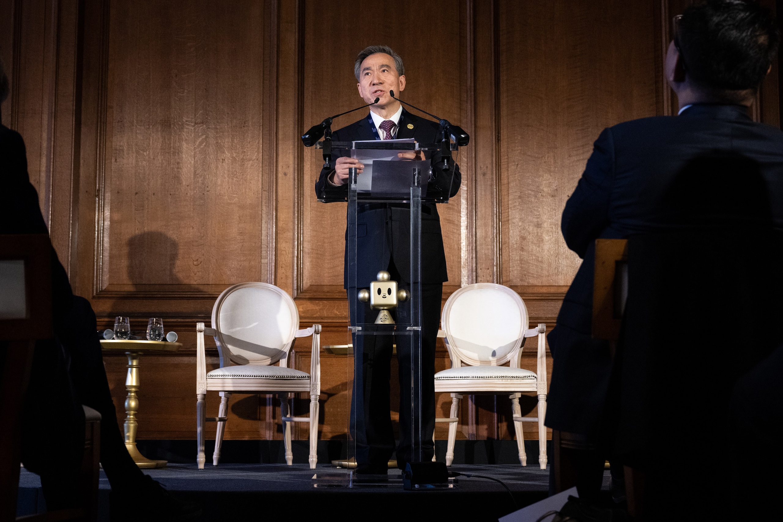 A Chinese man in suits speaks at an event