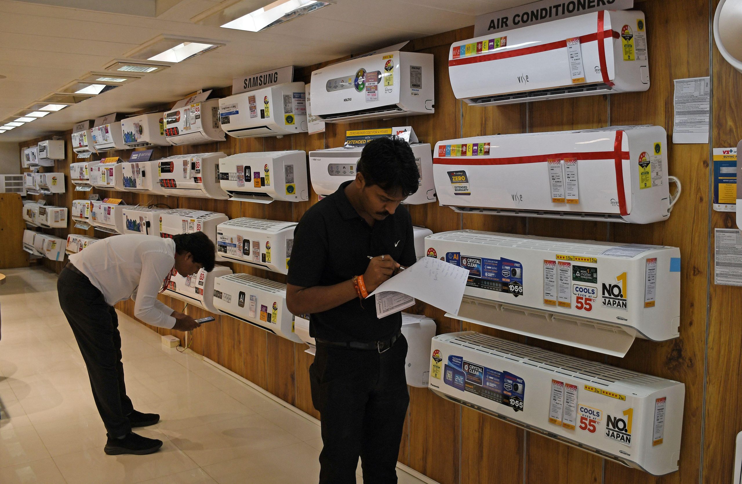 men standing near rows of air condition units on wall