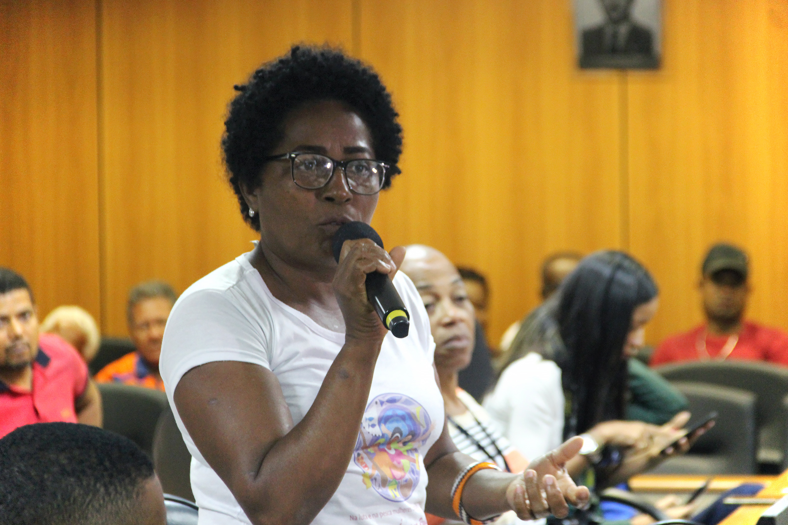 A woman speaking into a microphone in a room
