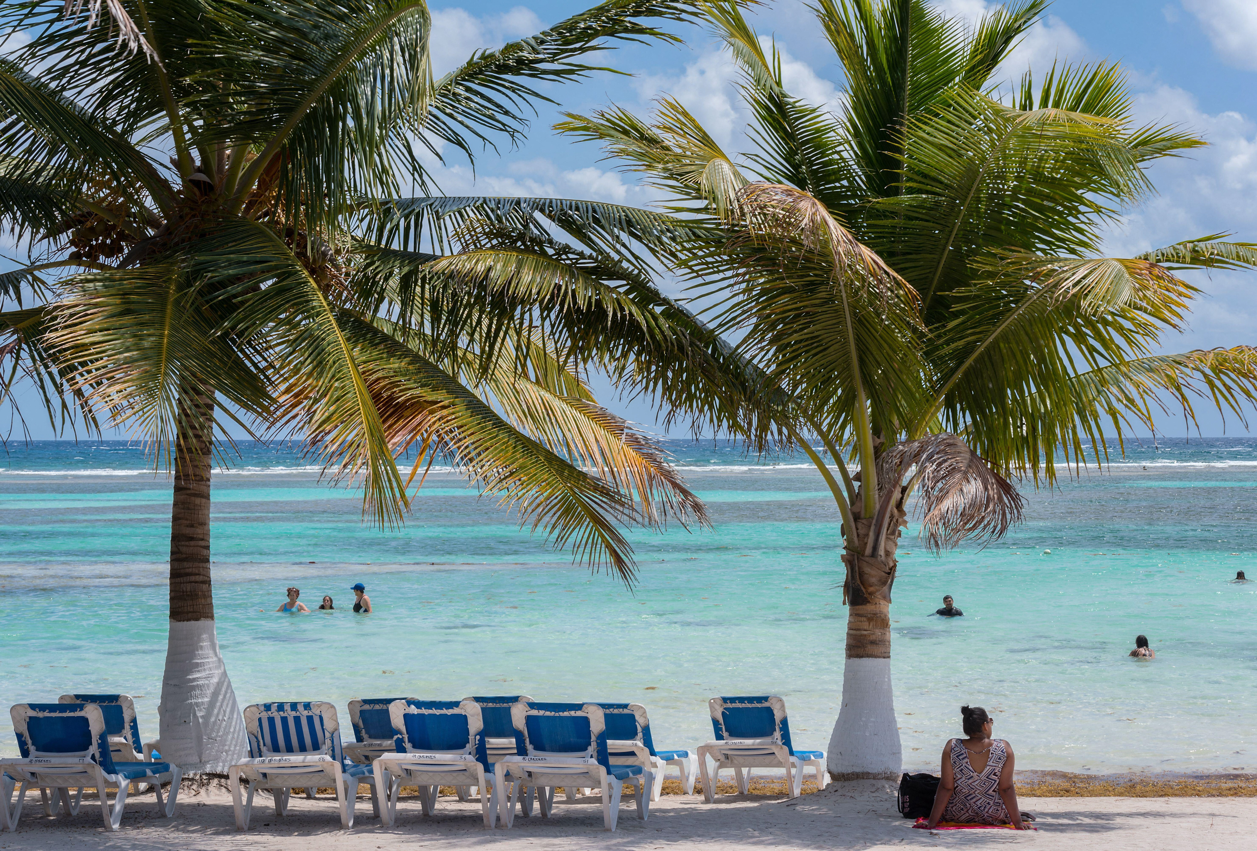 <p>Turistas na praia de Mahahual, estado de Quintana Roo, México. A região já atrai mais de um milhão de turistas ao ano, mas moradores e ativistas agora temem impactos ambientais da construção de um parque aquático na área (Imagem: Rainer Lesniewski / Alamy)</p>