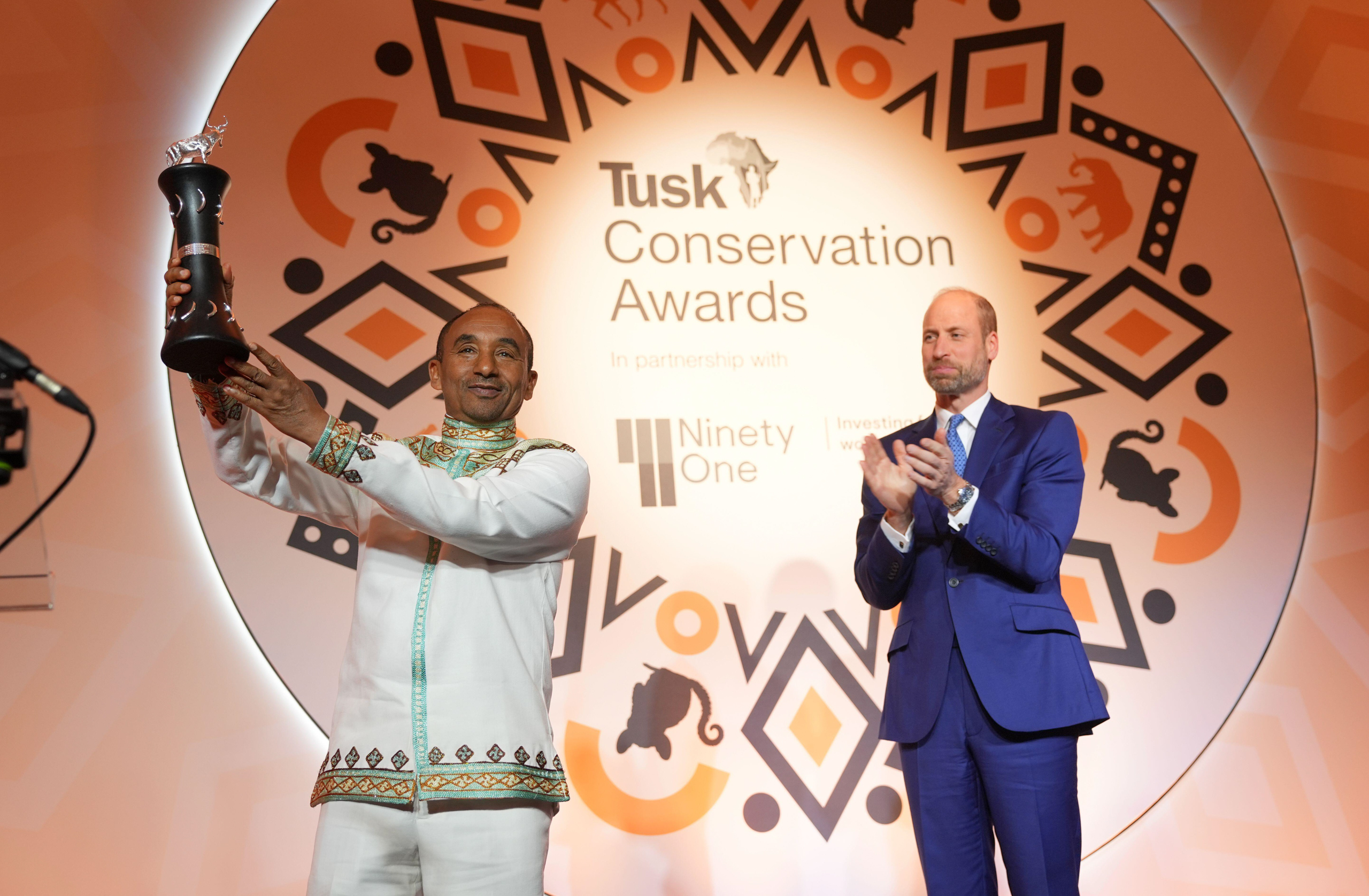 Kumara Wakjira holding award while Prince William claps