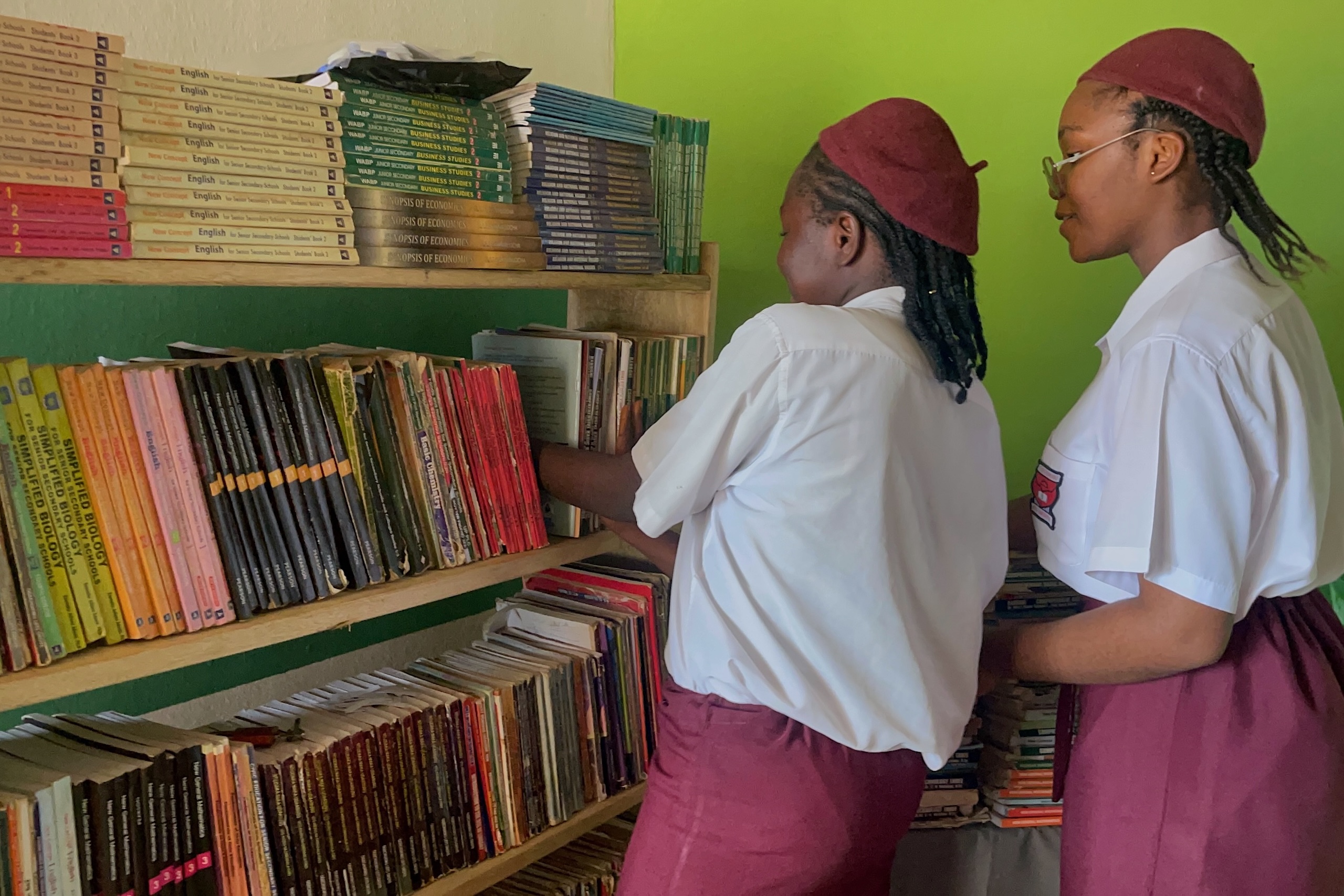 <p>Ossai Gift Chimdiuto and Ekwueme Chiziterem Noalene arrange books donated to their BookBank Africa project (Image: Jesse Ezezue Chukwudi, ICT / Media Support Volunteer Facilitator)</p>