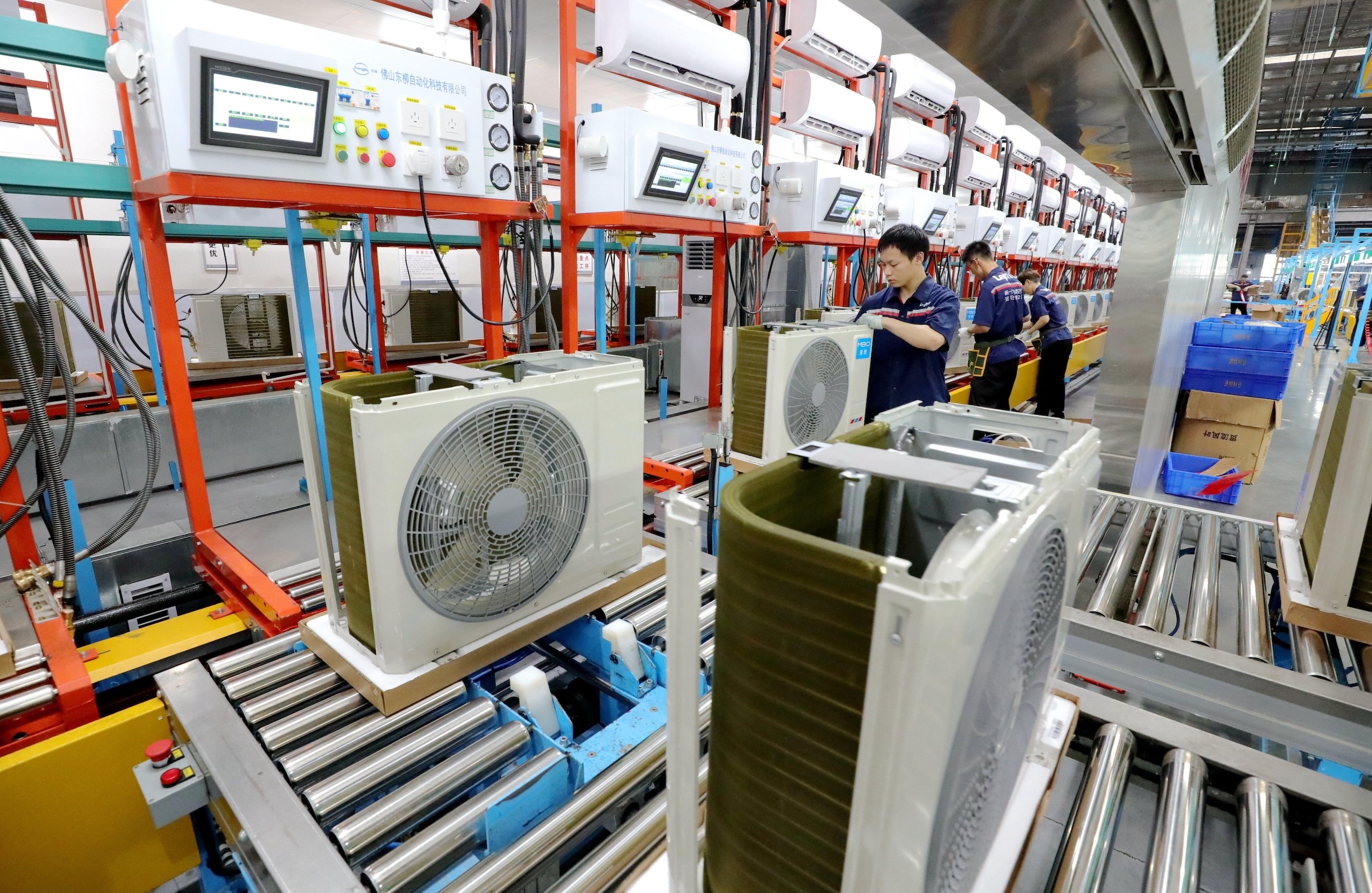 A technician is working on several air conditioning units in a workshop
