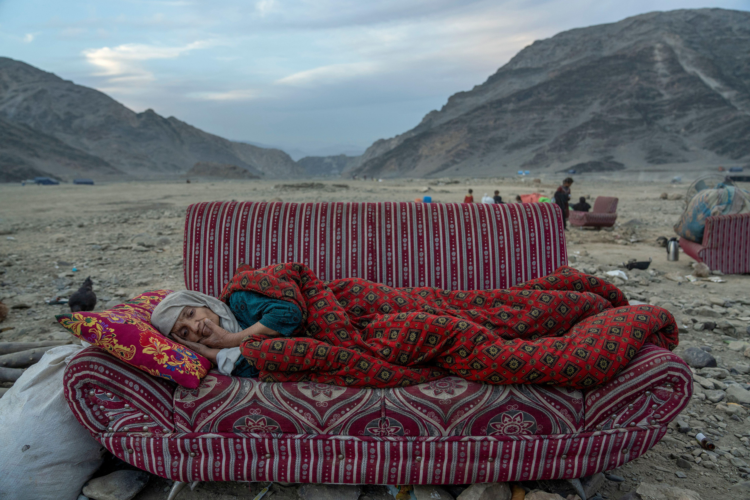 <p>An Afghan refugee rests in the desert beside a camp near the Pakistan-Afghanistan border in Torkham, Afghanistan in November 2023. Many Afghans arrived at the Torkham crossing shortly before the expiration of a Pakistani government deadline for mass repatriation (Image: Ebrahim Noroozi / AP / Alamy)</p>