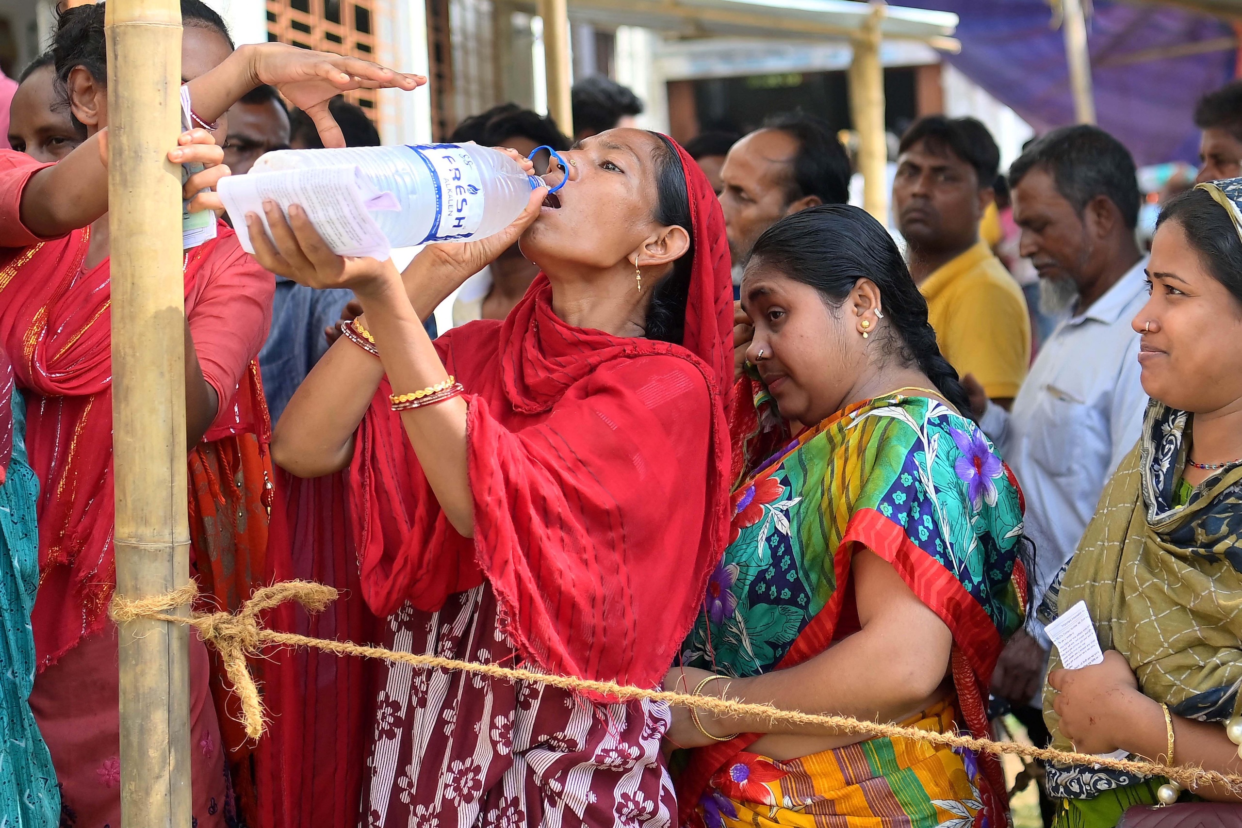 <p>A woman rehydrates while waiting in line to cast her vote in the April 2024 general elections in Agartala, the capital of the Indian state of Tripura (Image: Abhisek Saha / Majority World CIC / Alamy)</p>