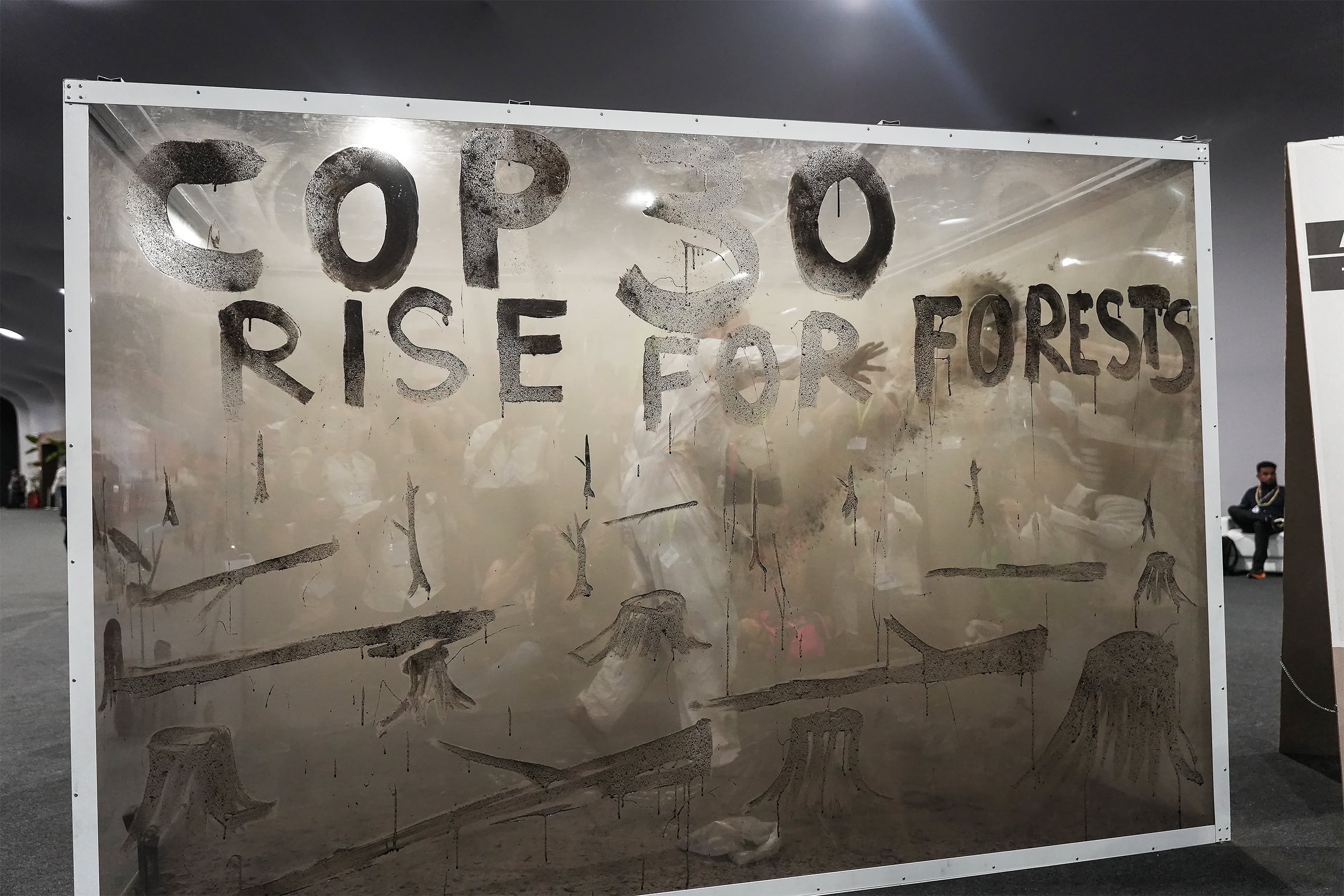 Instalación artística con cenizas que dice "COP30 rise for forests"